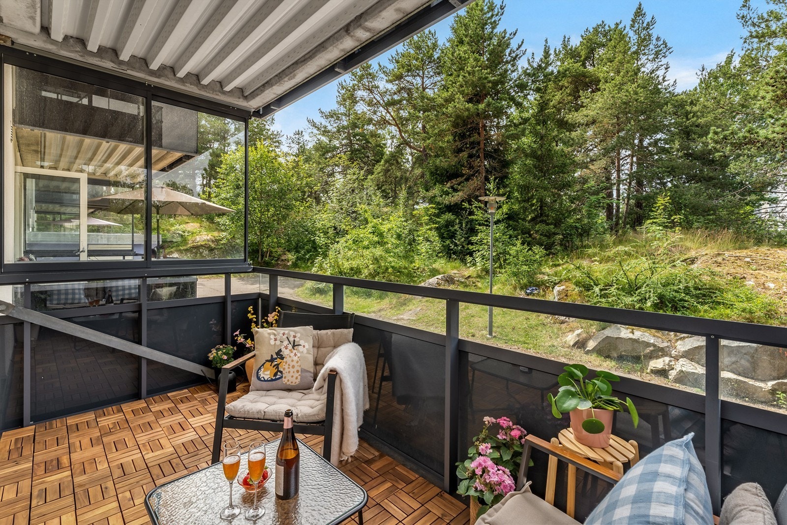 Koselig og solrik vestvendt balkong som vender mot rolig skogsområde Galleribilde