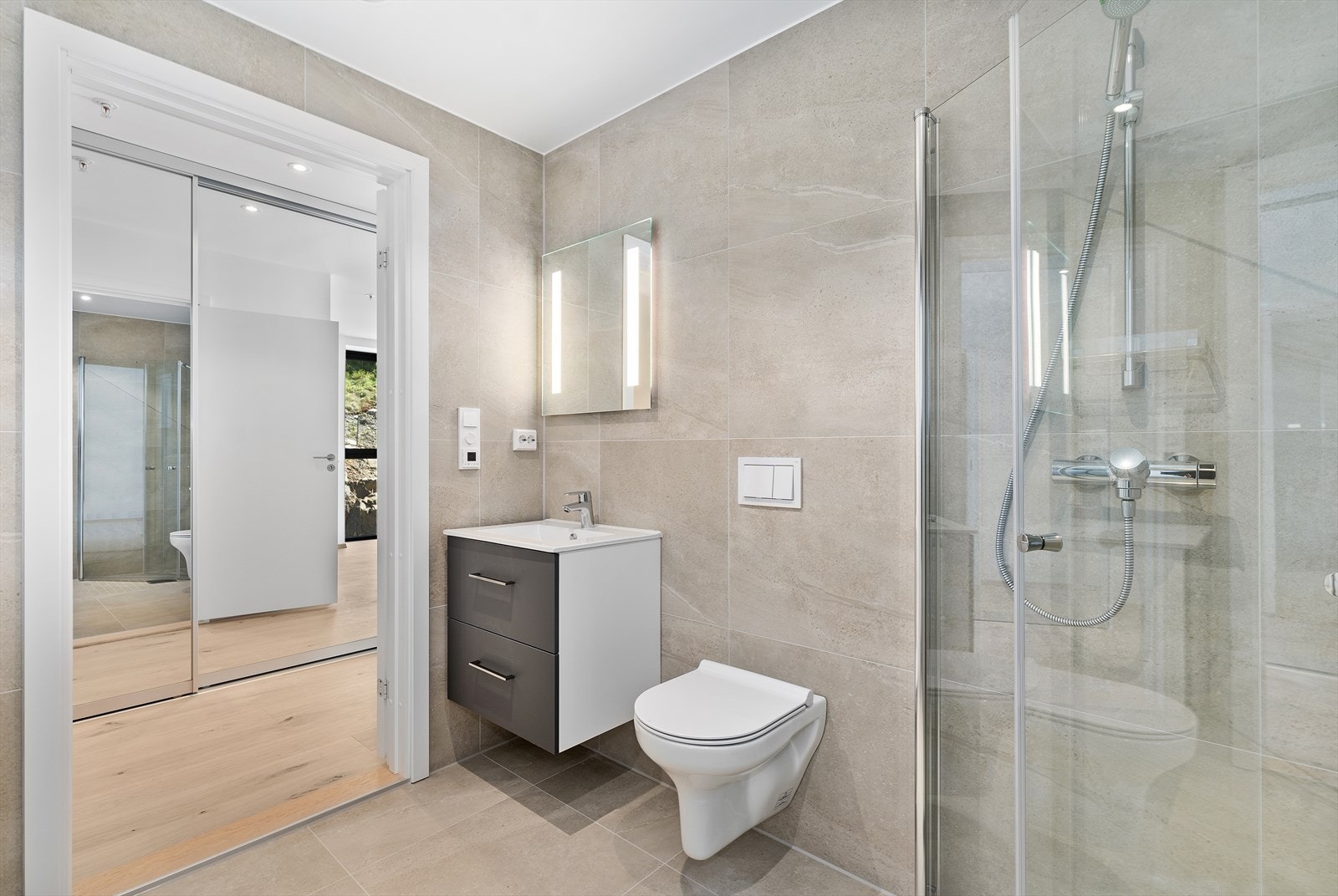 Bad med servant, vegghengt wc og dusjhjørne. Galleribilde