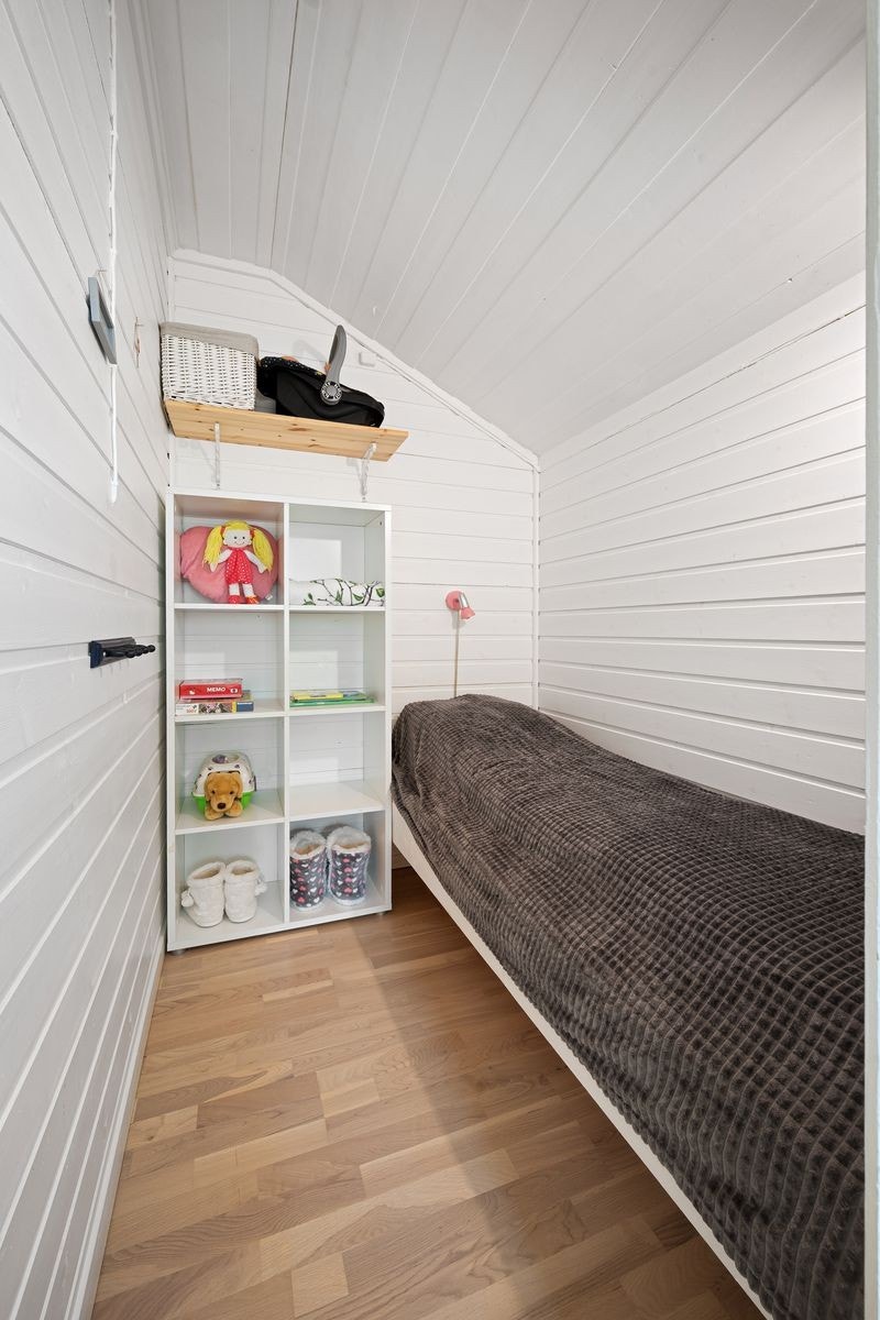 Koselig, lyst rom med skråtak og trepanel, perfekt som barnerom eller liten gjesteromsløsning. Praktisk oppbevaringsmulighet. Galleribilde