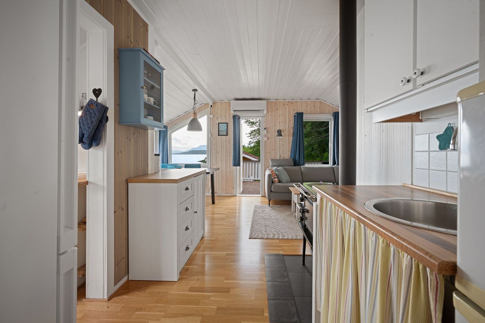 Lys og innbydende stue med store vinduer som gir fantastisk utsikt mot sjøen. Galleribilde