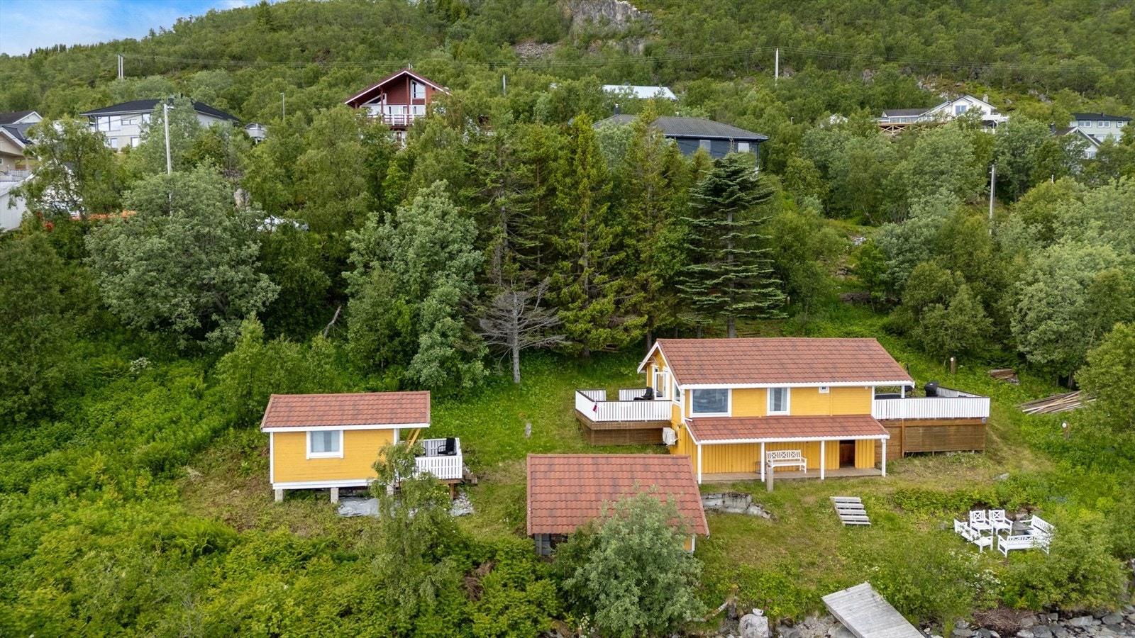 Sjarmerende gul hytte med rødt tak, idyllisk beliggende i grønne omgivelser. Perfekt for naturnære opplevelser og avslapning. Galleribilde