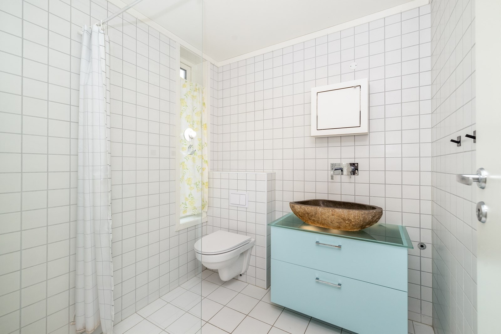 Flott baderom med overflater bestående av flis på vegger, flislagt gulv med elektriske varmekabler samt malte slette flater i himling. Galleribilde