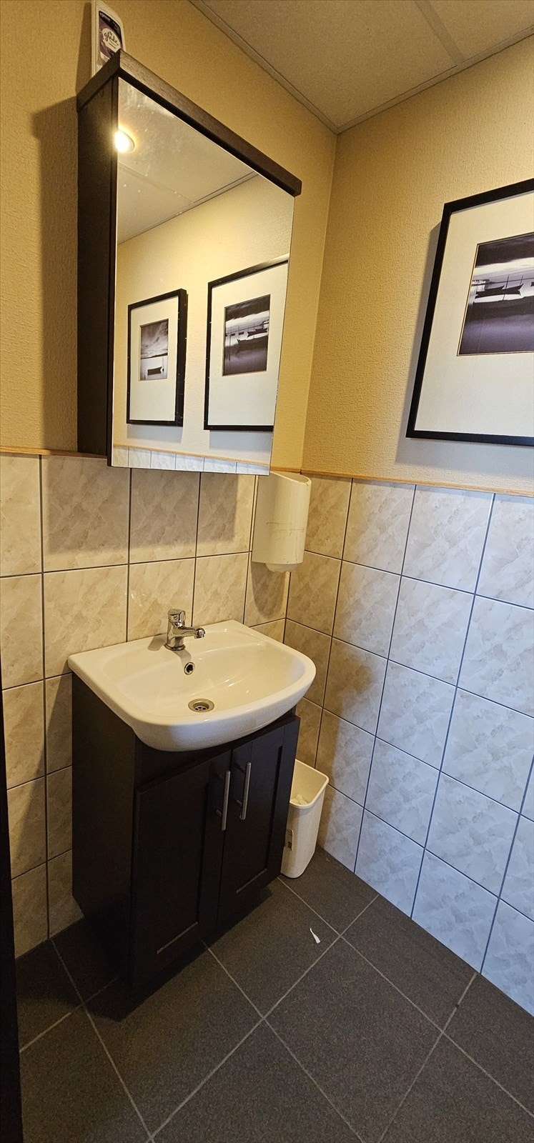 Baderom med flis på gulv og deler av veggene. Galleribilde