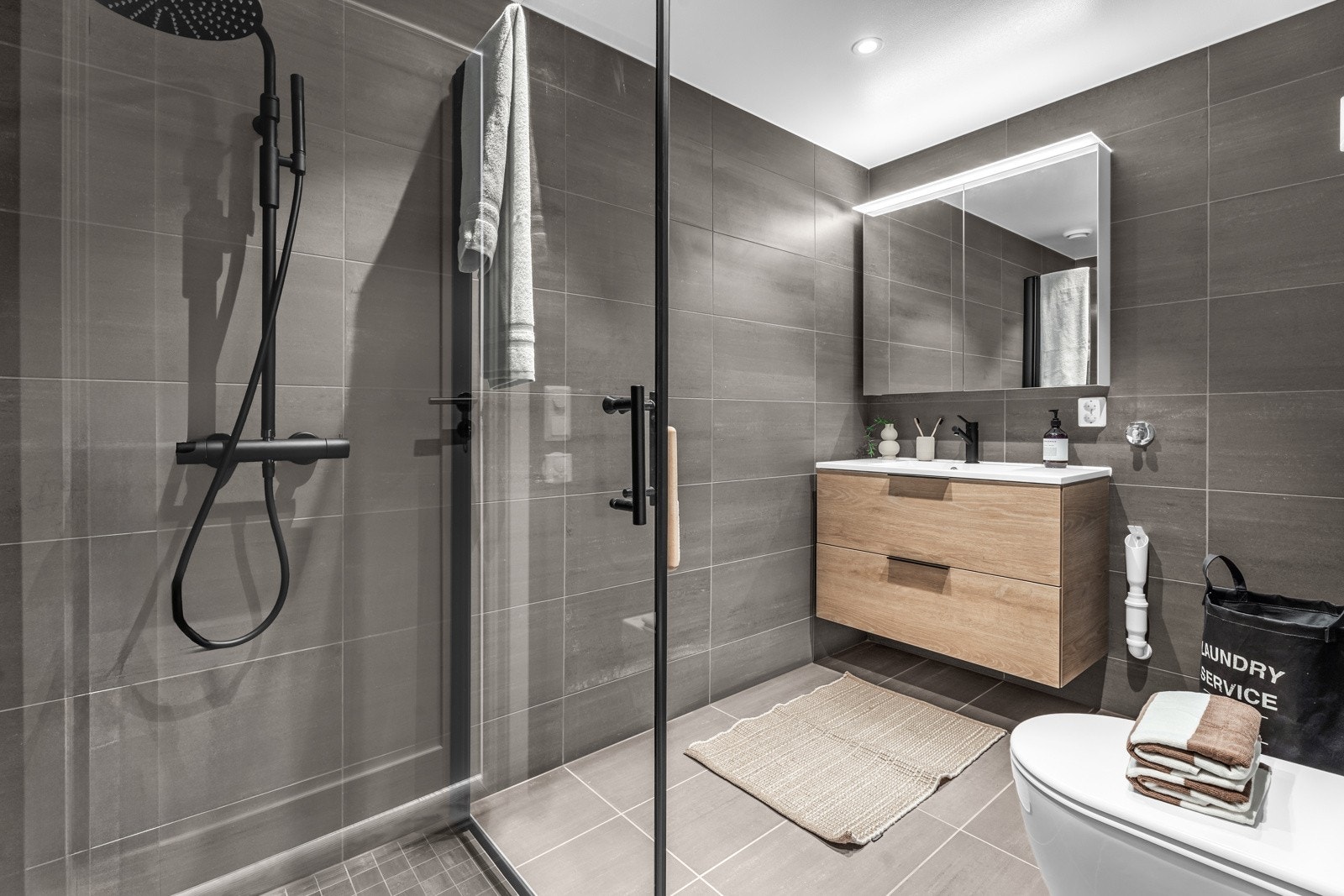 Delikat baderom med gulvvarme og opplegg for vaskemaskin Galleribilde