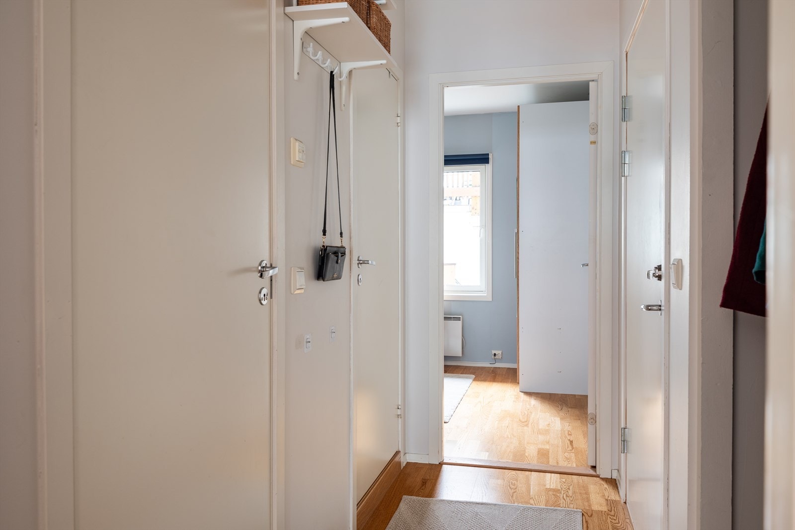 Gang/entré mellom stue og soverom, med integrert garderobeskap med speilfronter. Galleribilde