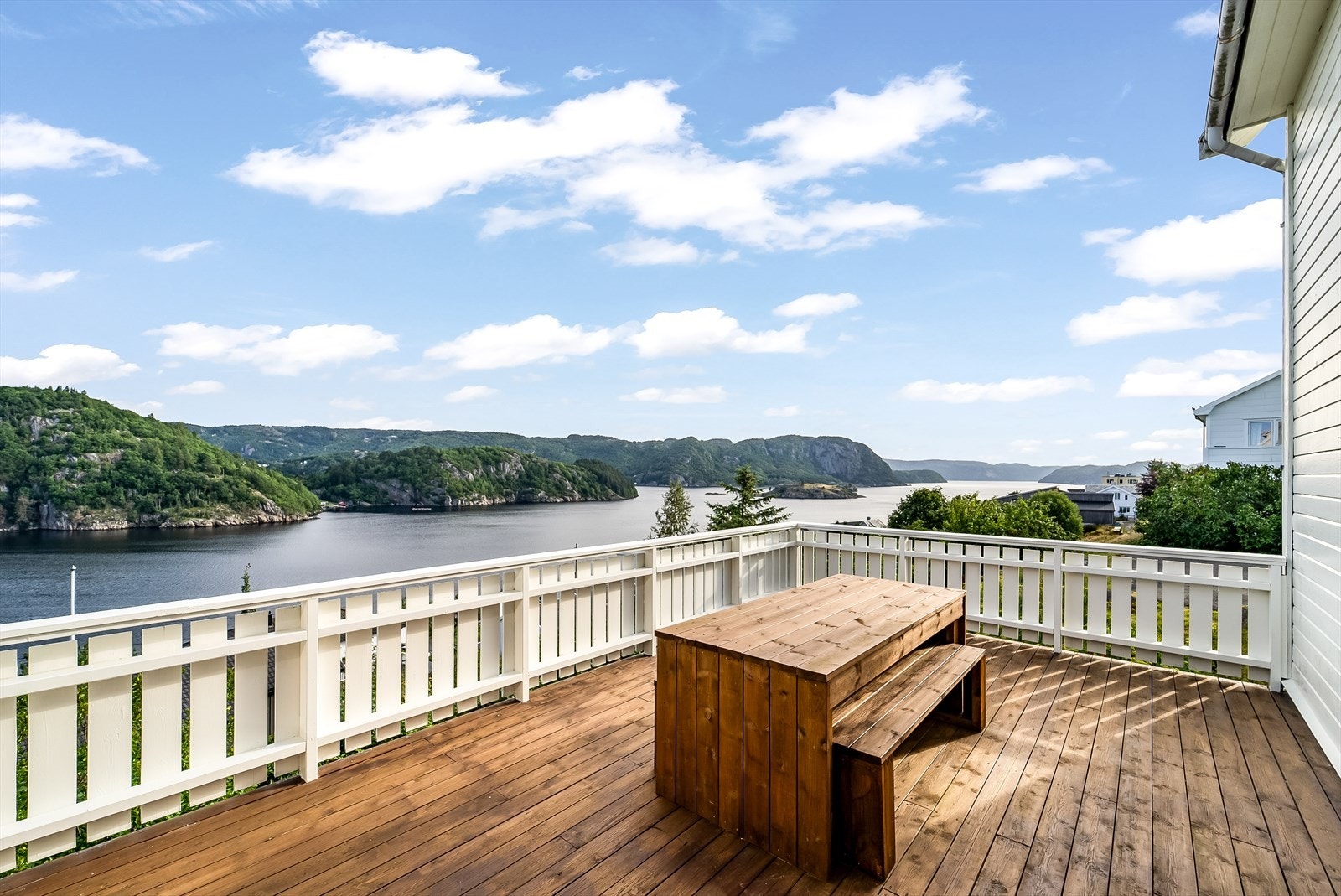 Utsikten mot fjorden kan nytes fra flere hold. Her fra terrassen i front med utgang fra vinterhagen. På sommeren kan man se soloppgangen. Galleribilde