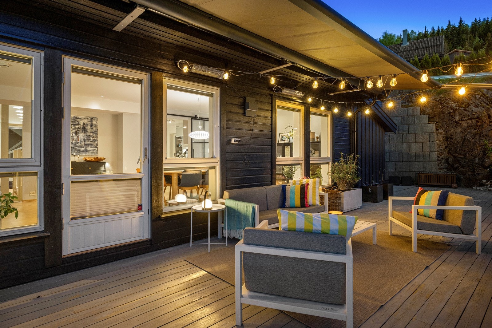 Uteplassen har dekke av terrassebord og er pent bygd inntil fjellknauser, støttemur og noe plenareal. Galleribilde