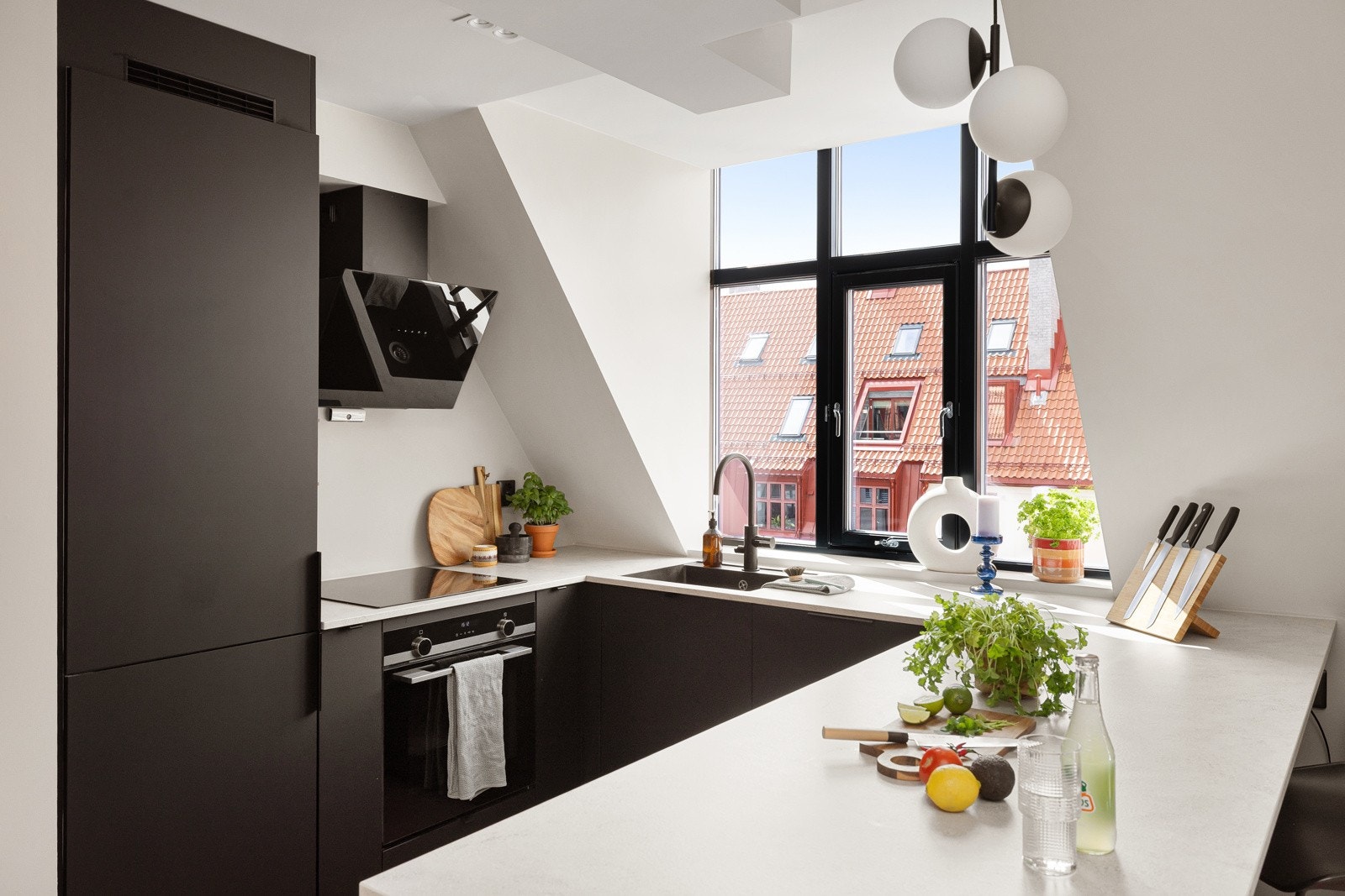 Stilrent og moderne Kvik-kjøkken fra 2019. Innredningen har sorte glatte fronter, lys laminert benkeplate med underlimt sort oppvaskkum og stilig sort armatur. Galleribilde