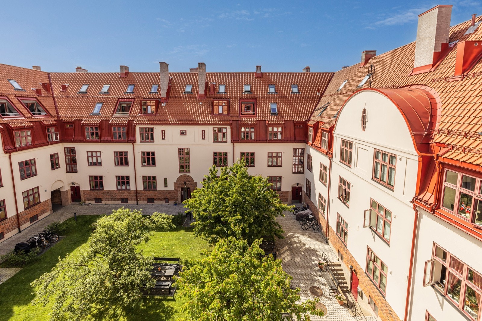 Hyggelig utsyn over sameiets bakgård som er pent opparbeidet med plen og beplantning. Galleribilde