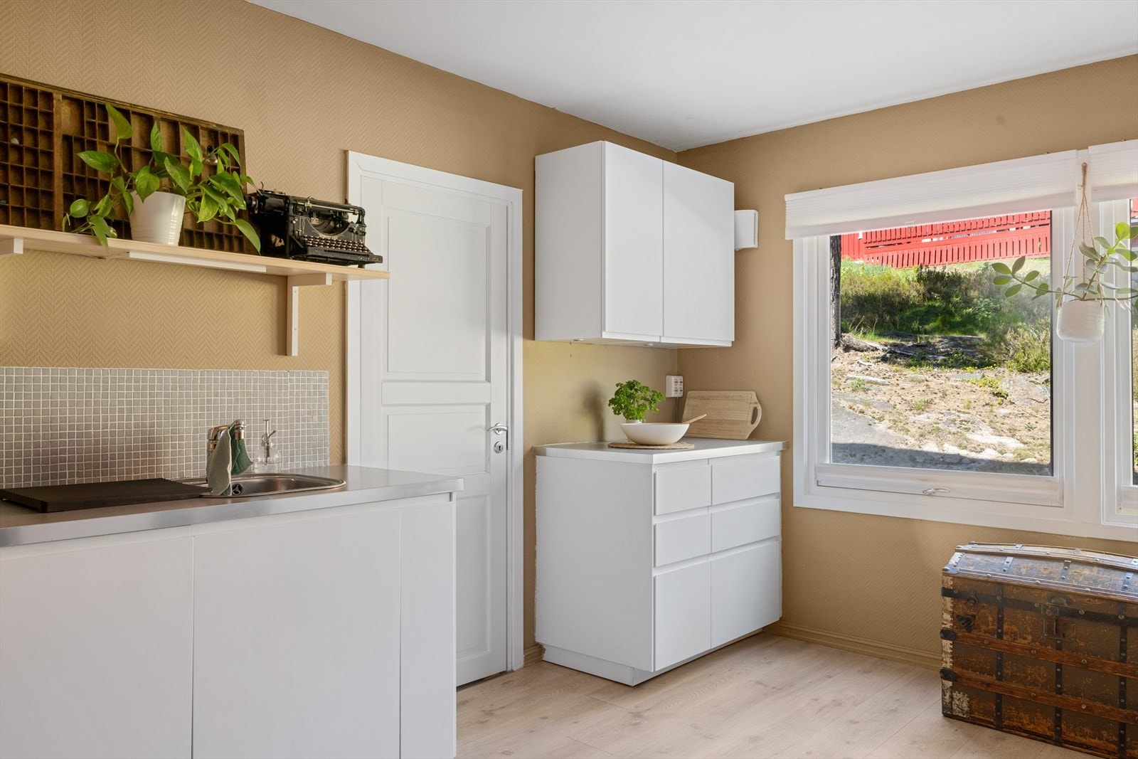 Kjøkkenet har glatte fronter med integrerte håndtak, laminat benkeplate med nedfelt oppvaskkum og ettgreps blandebatteri. Galleribilde