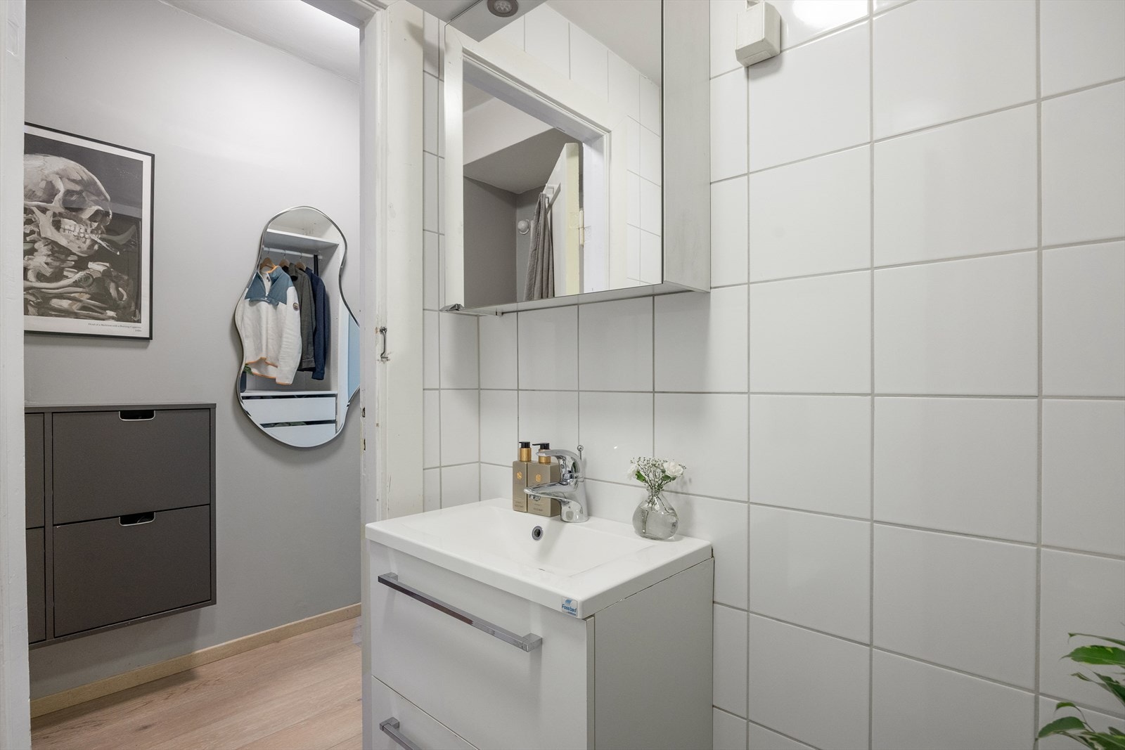 Baderommet er innredet med klosett, servantskap med glatte, folierte fronter, speil og dusjhjørne med svingbare foldedører. Galleribilde