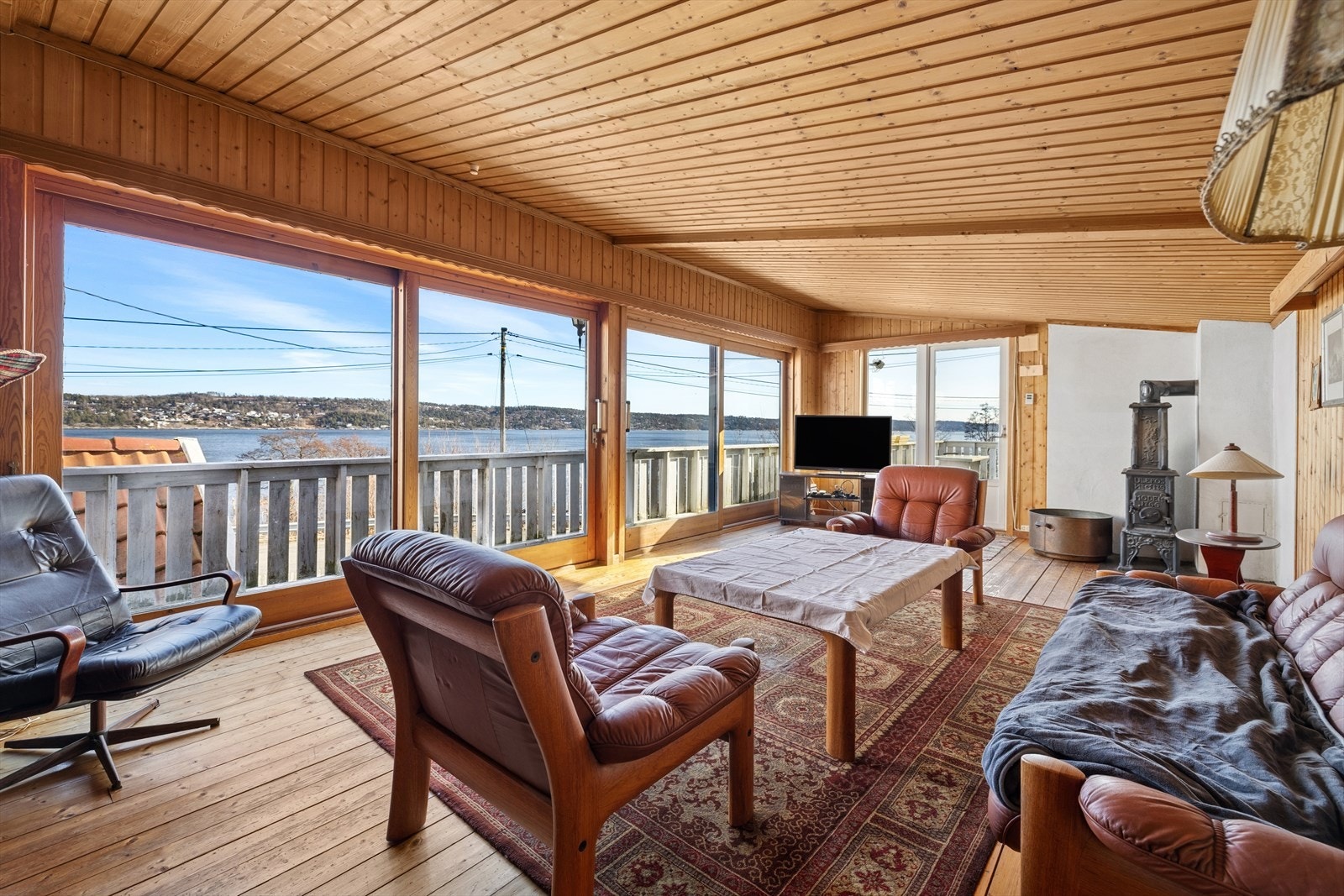 Romslig stue med mye naturlig lys samt utgang til terrasse med fantastisk fjordutsikt Galleribilde