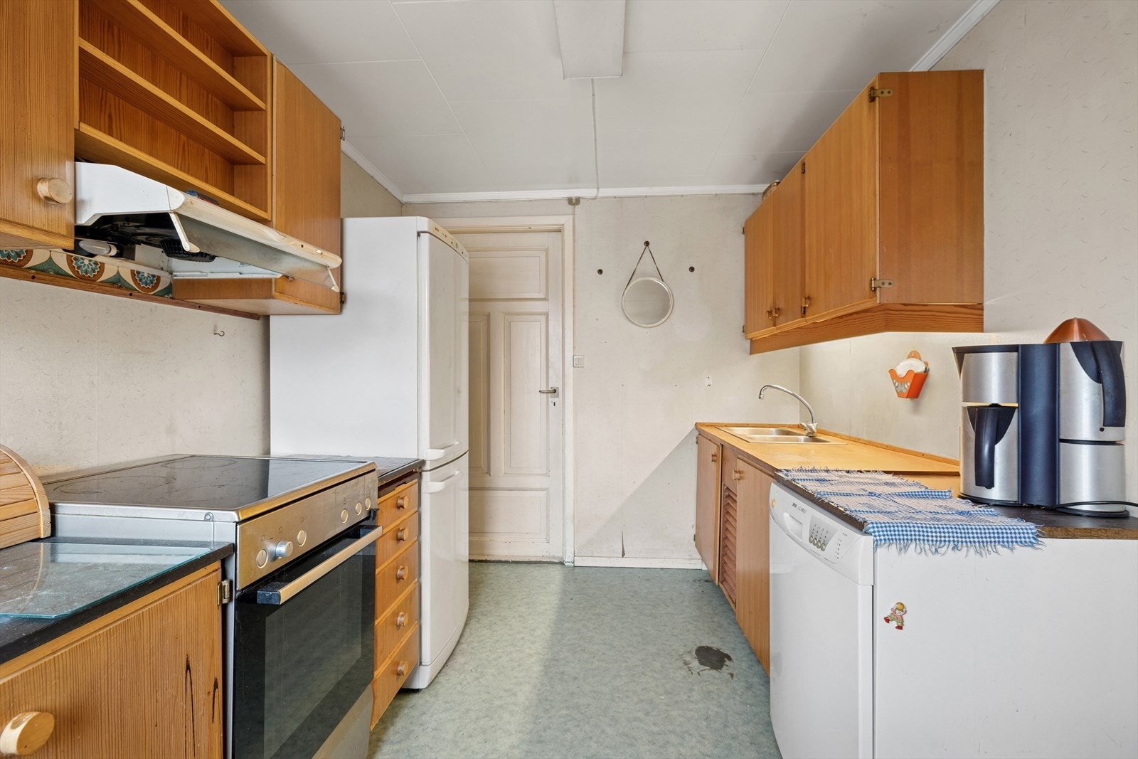 Kjøkkenet har en innredning med glatte fronter, heltre benkeplate, belysning under overskap, opplegg for oppvaskmaskin og benkebeslag med rustfritt stål med to kummer. Galleribilde