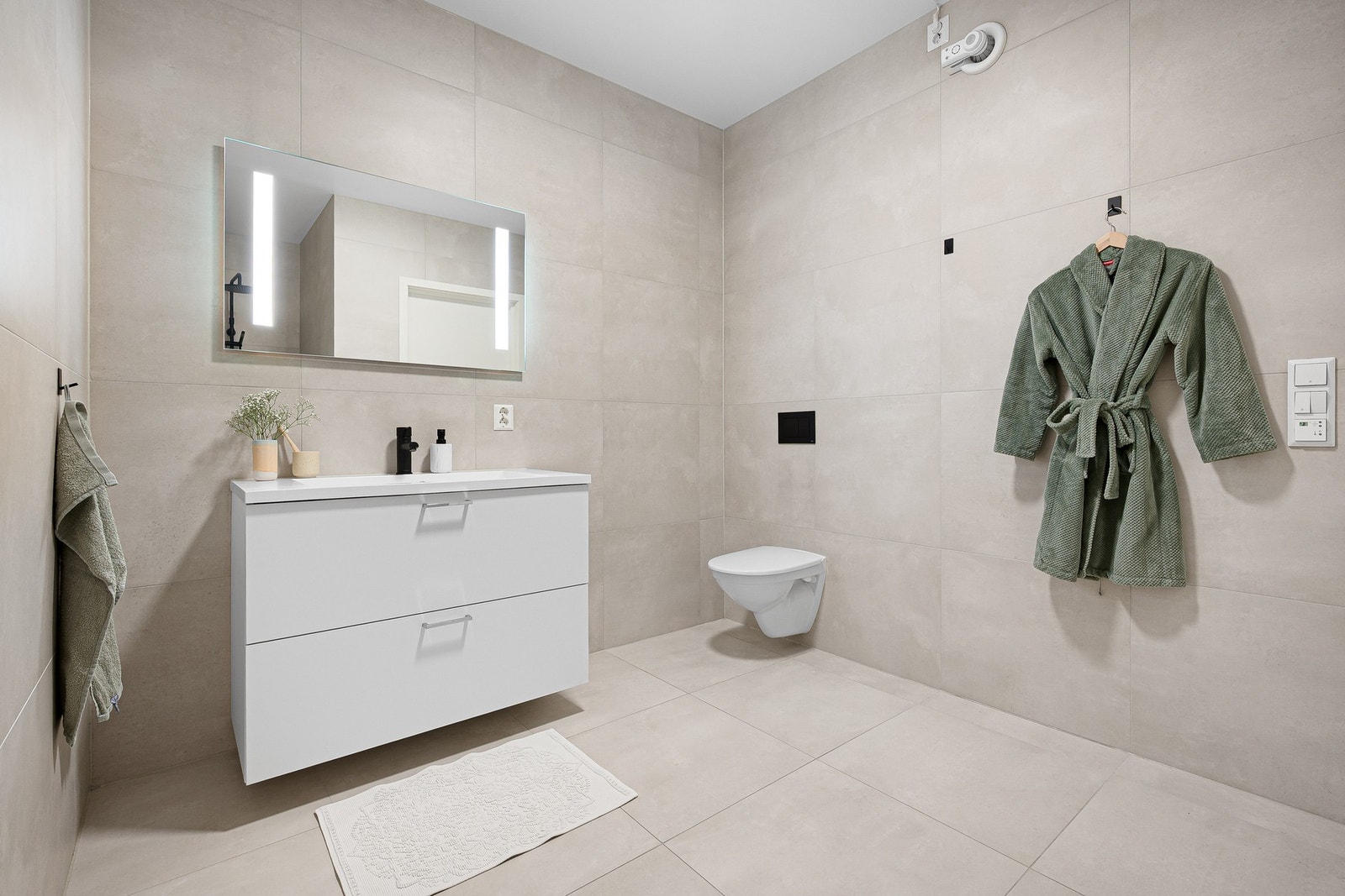 Her får du et stort og moderne bad med 7 kvm, elegante fliser og komfortabel gulvvarme. Galleribilde