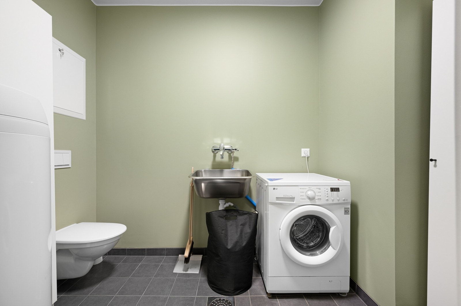 Praktisk og romslig vaskerom med servant, ekstra toalett og opplegg for vaskemaskin - perfekt for en effektiv hverdag. Galleribilde