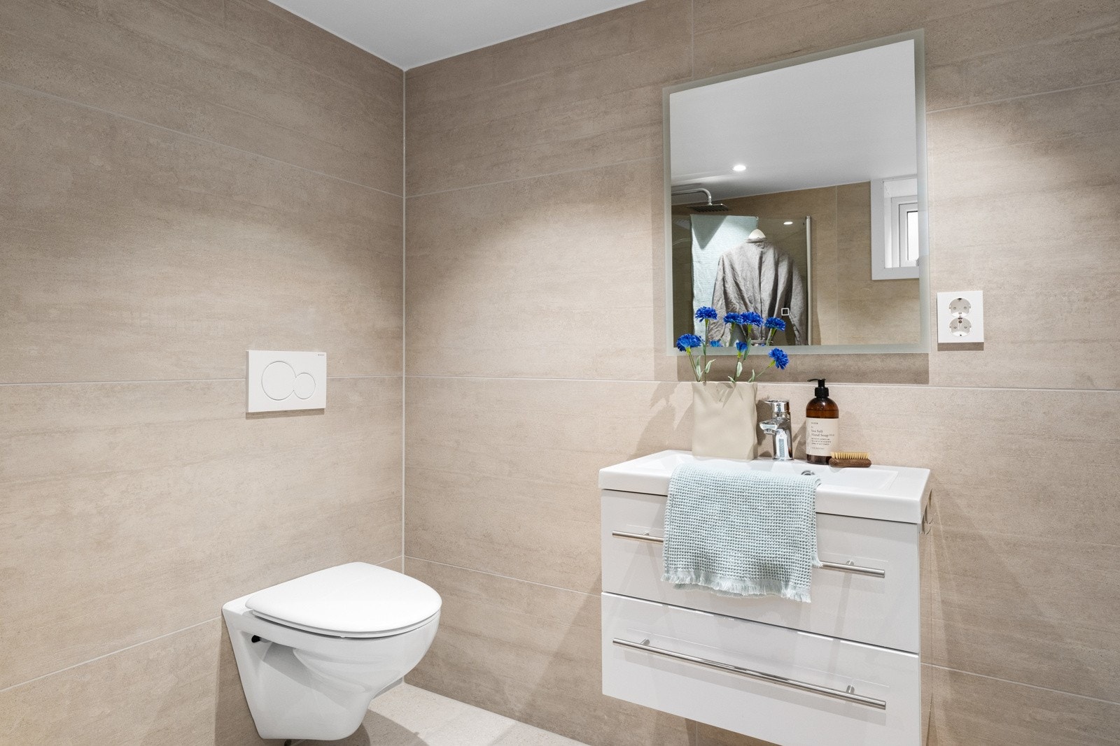 - Badet inneholder: vegghengt toalett, helstøpt servant, skuffer under servant med slette fronter og dusjdører i klart glass - Galleribilde