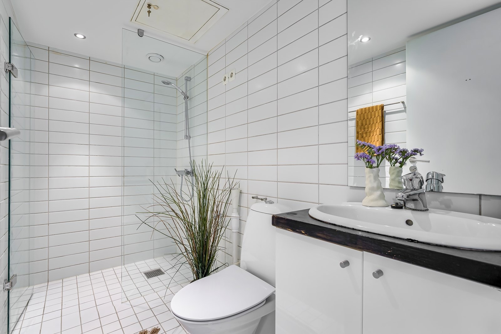 Pent flislagt bad med gulvvarme og downlights i himlingen Galleribilde