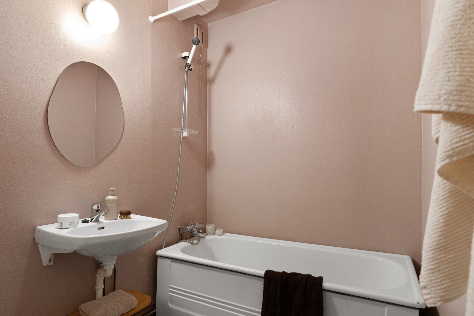 Rommet har malte flater på gulv, vegger og himling, samt inneholder badekar, gulvmontert klosett, veggmontert servant, speil og lysarmatur. Galleribilde