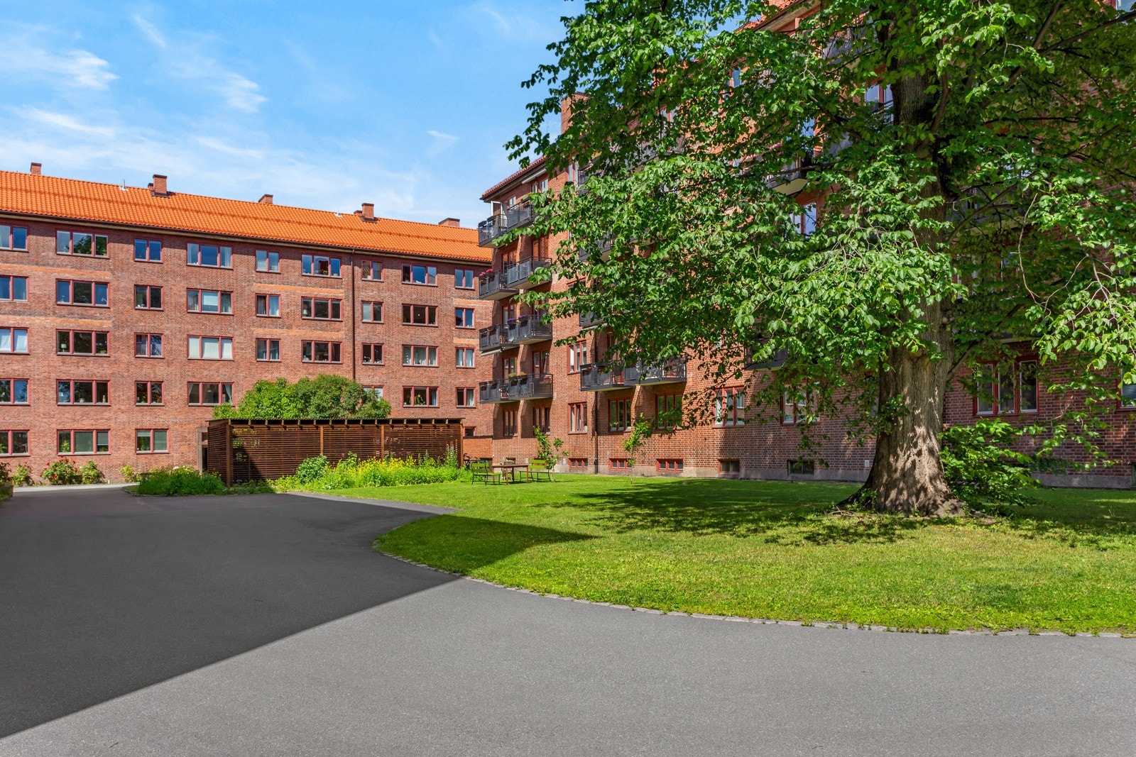 Gårdsrommet er pent opparbeidet med asfalt og grøntarealer. Her er det også tilgang til en felles sykkelbod. Galleribilde