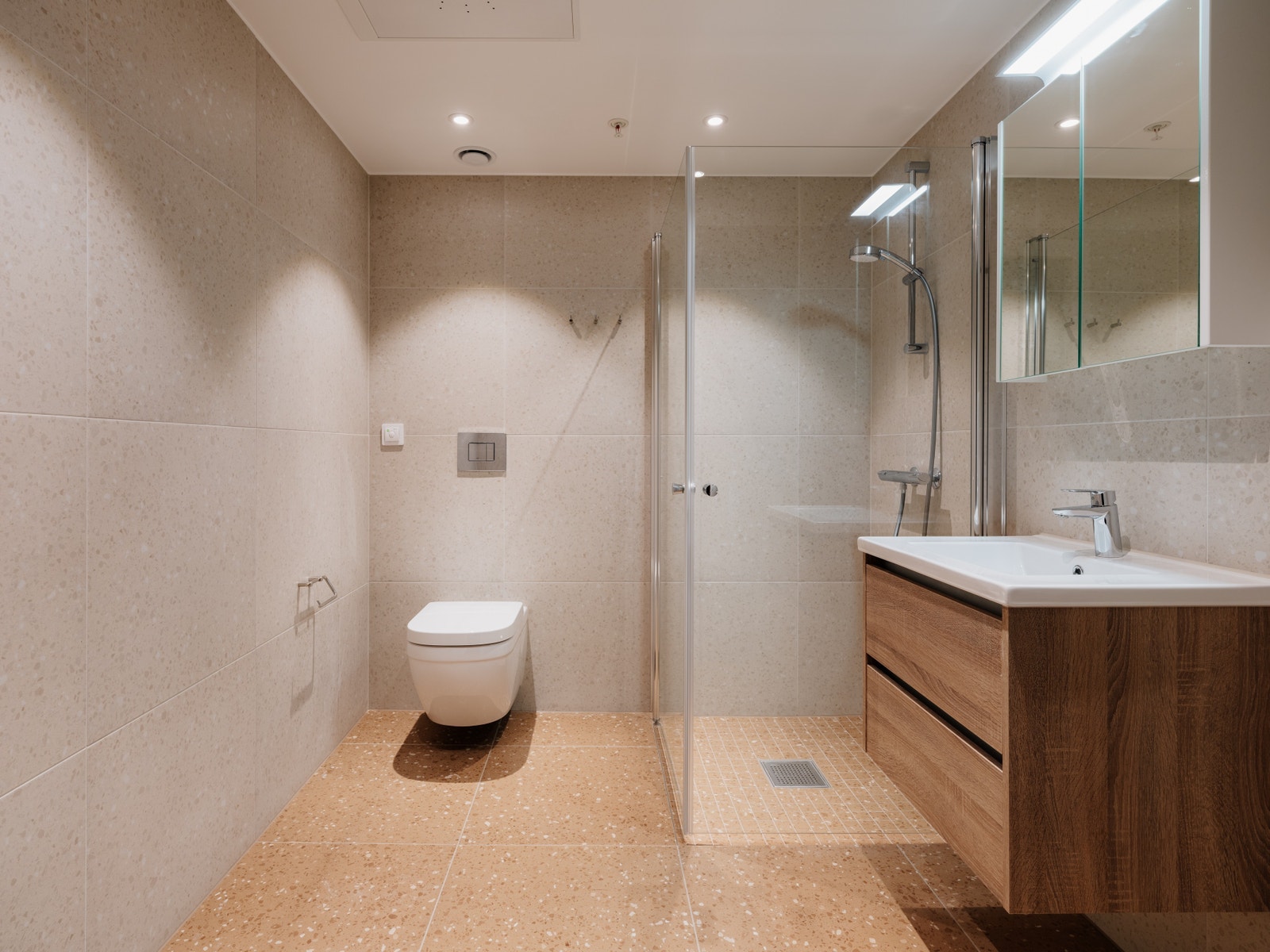 Lekkert flislagt bad med dusjnisje, servant og wc Galleribilde