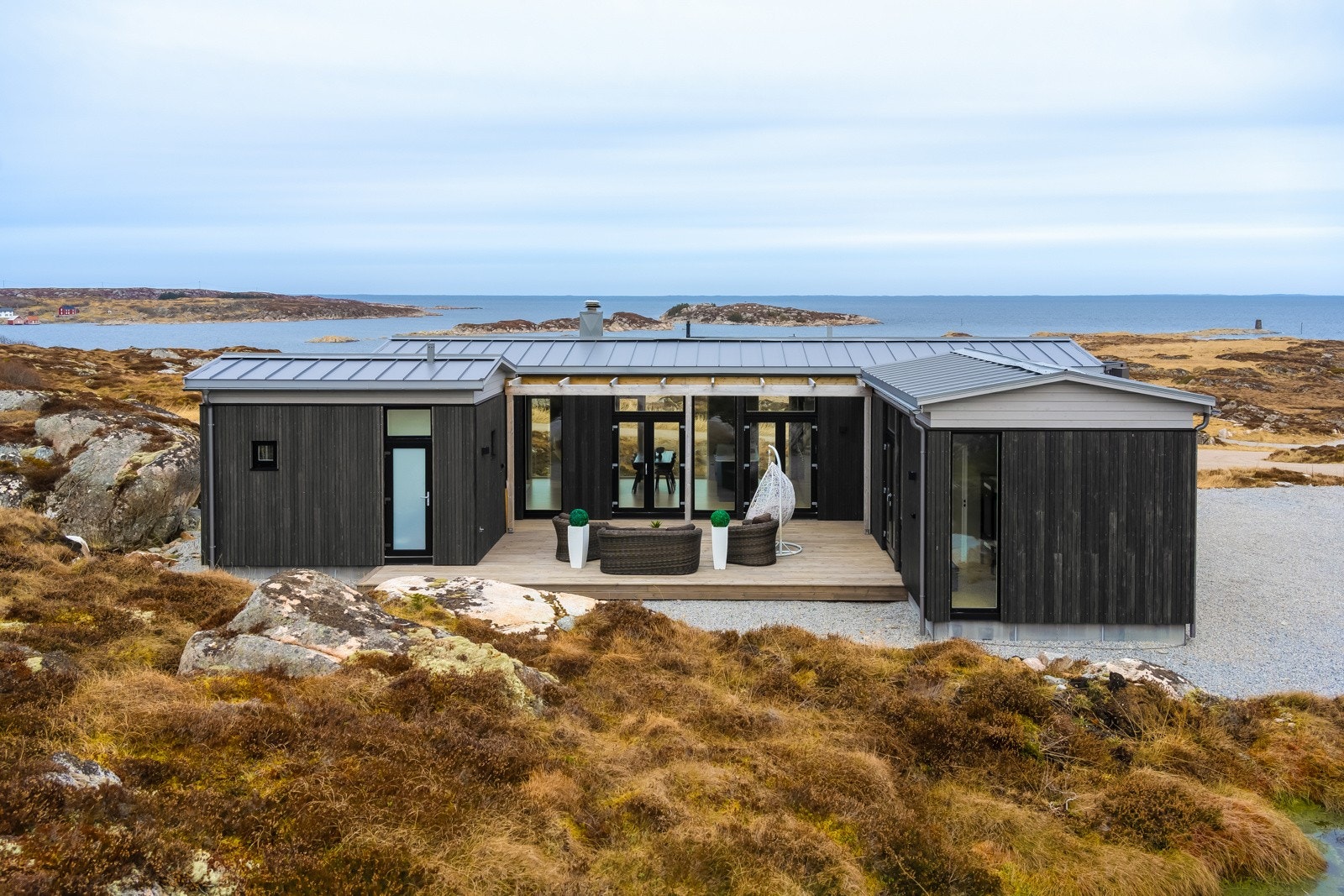 Nyt sommeren, skjermet fra vind i svale omgivelser på terrassen. Legg merke til utsikten gjennom hytten Galleribilde