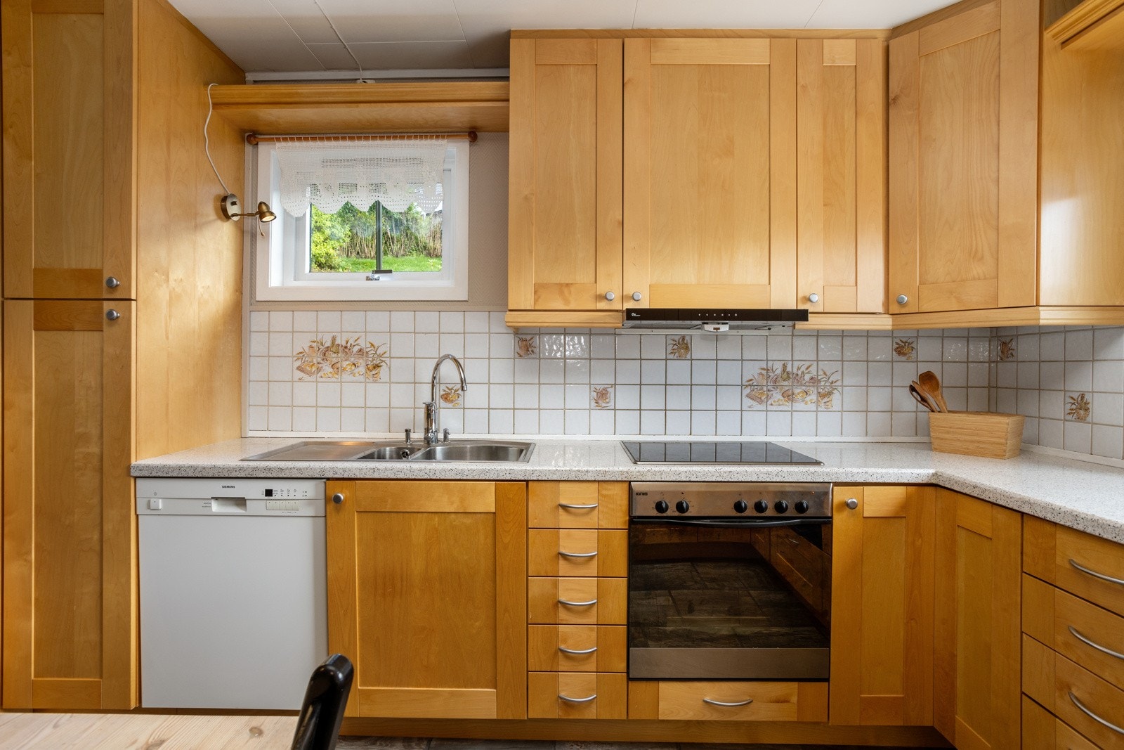 Det er godt med benke- og skapplass. Fliser over kjøkkenbenk. Galleribilde