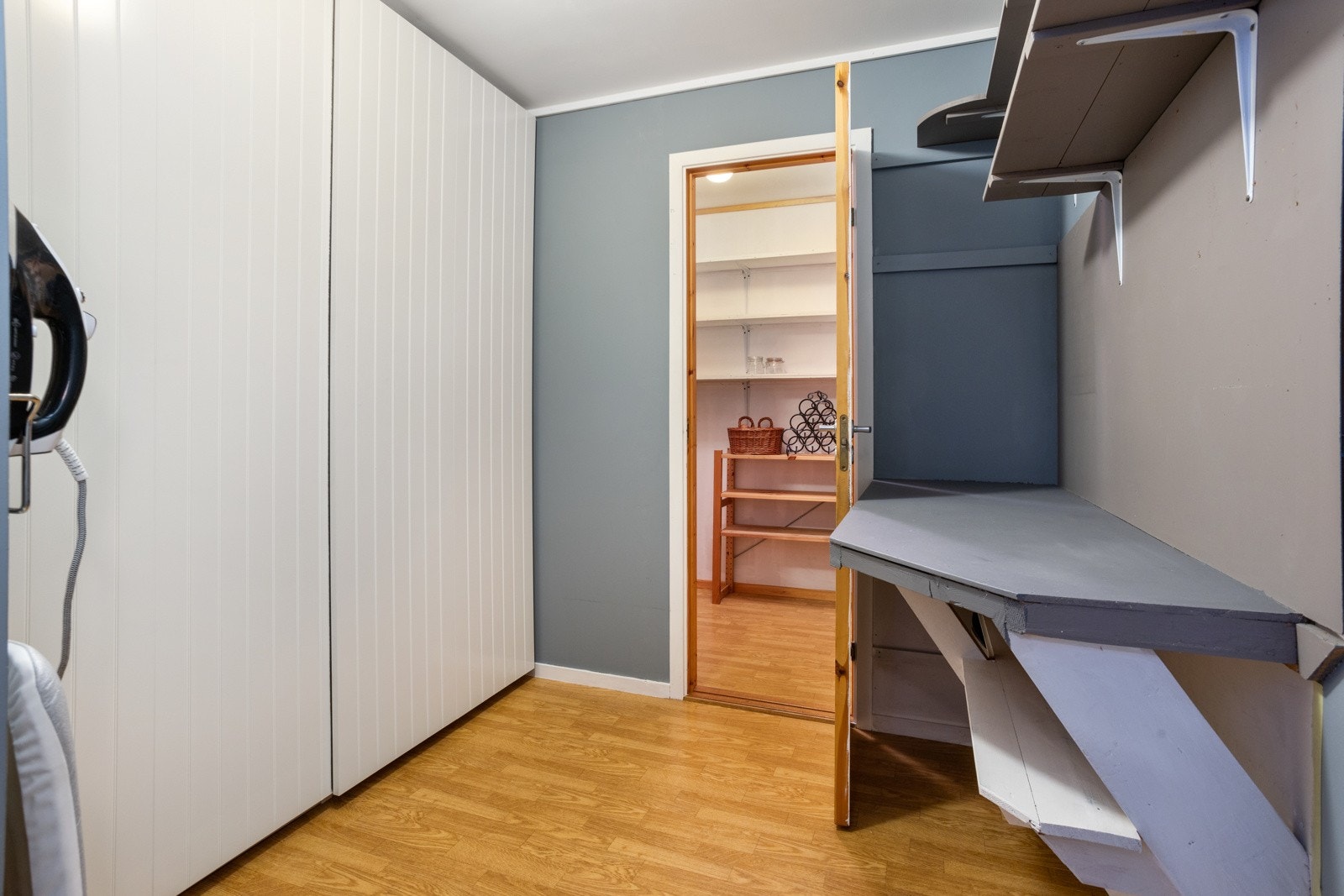 Stor lys bod. Garderobeskap langs hele veggen med 2 skuffeseksjoner. Galleribilde