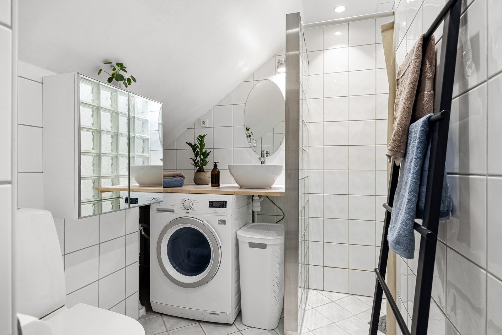 Badet er innredet med toalett, servant med benkeplate i laminat, separat dusjnisje og veggskap med speildør. Galleribilde