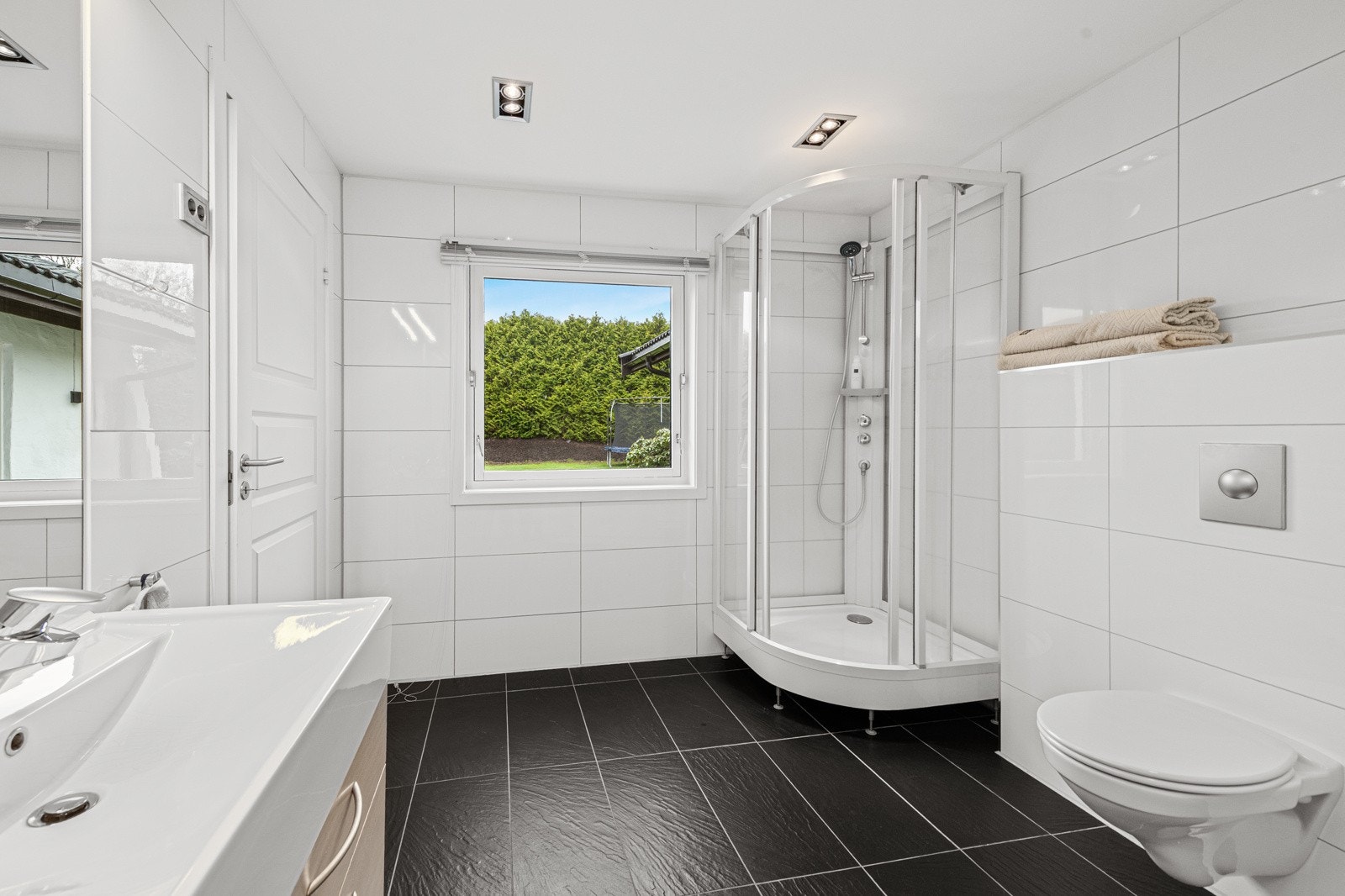Stort vindu som gir fint med naturlig lys inn på badet Galleribilde