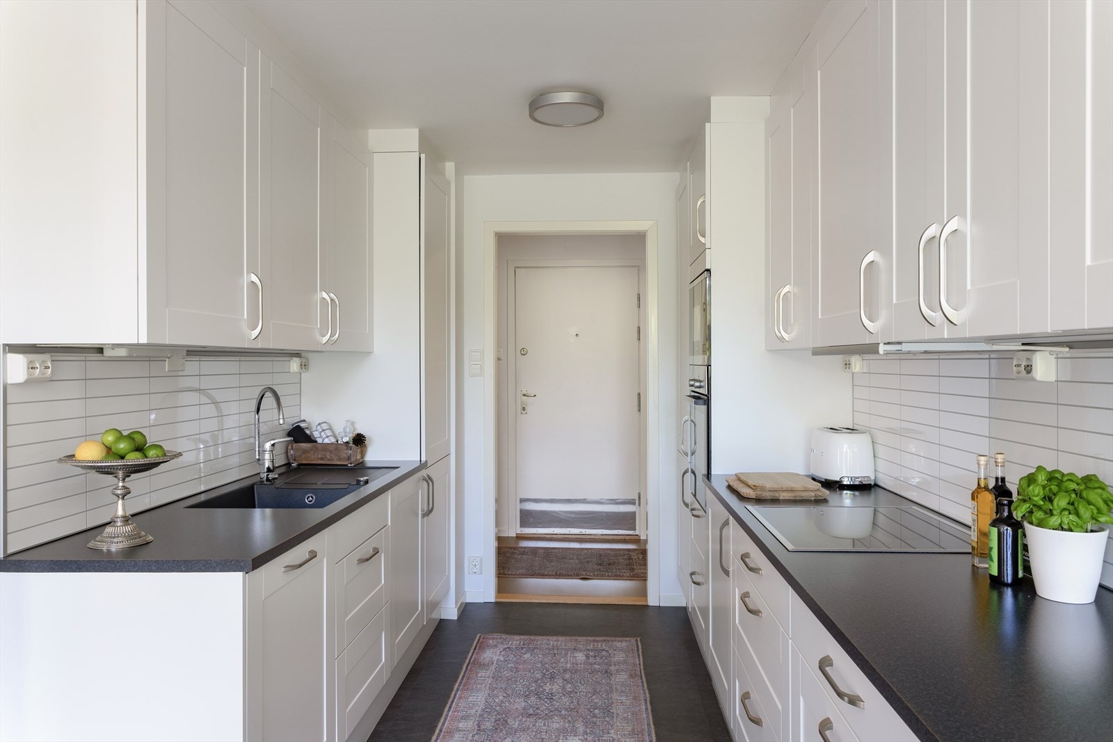 Kjøkkenet har folierte 1-speils fronter, laminat benkeplate med planlimt kum og ventilator tilsluttet kanal. Galleribilde