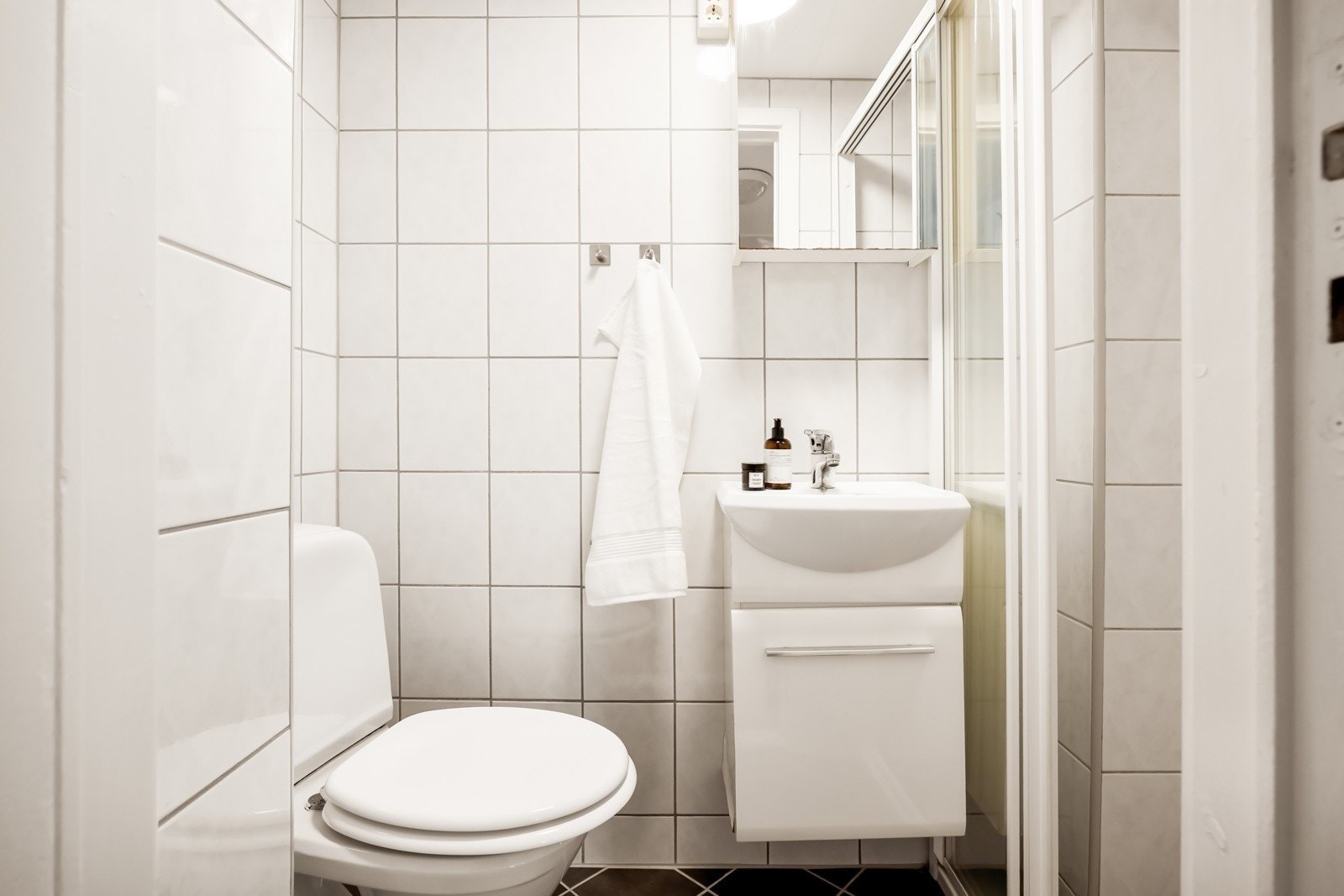 Lyst og tidløst bad med keramiske fliser på gulv og vegger. Galleribilde