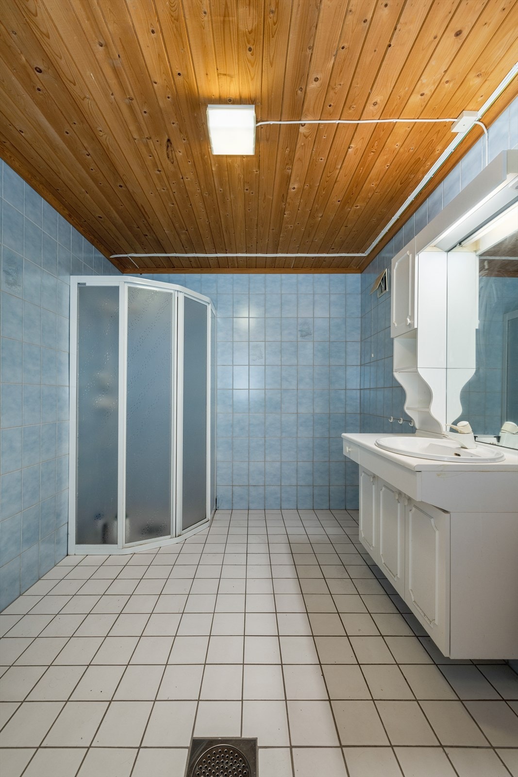 Bad er fra 1990 og har flis på gulv og vegger. Badet er 8 kvm stort, og inneholder dusjnisje og innredning. Ventil i vegg. Galleribilde