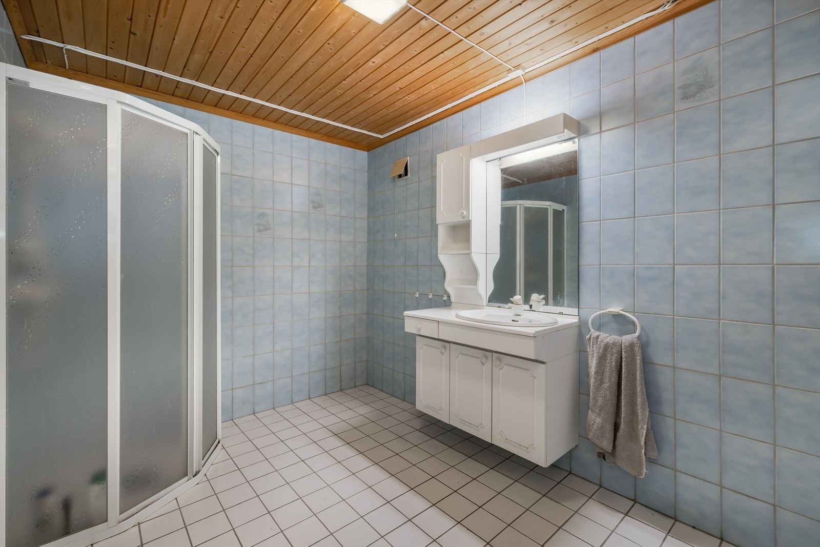 Innredningen har benkeplate med vask, under- og sideskap med profilerte fronter og speil med lys. Galleribilde