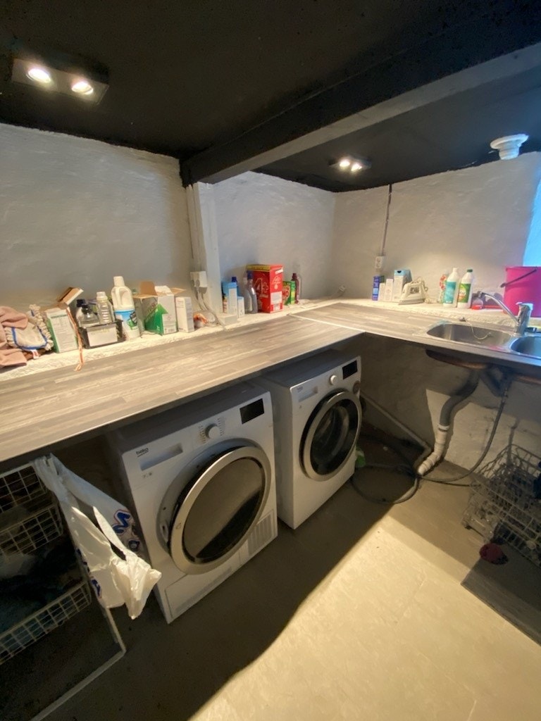 Vaskerom med vaskemaskin og tørketrommel. Strykejern og strykebrett Galleribilde