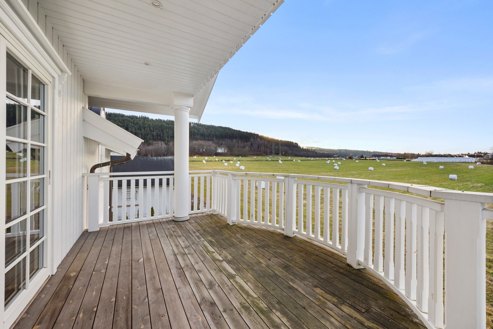 Vestvendt balkong vendt ut mot det åpne jordet. Galleribilde