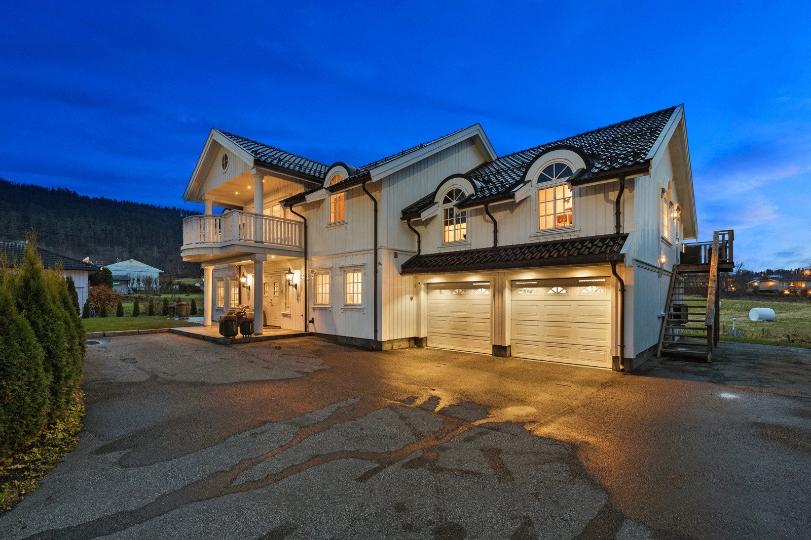 Asfaltert gårdsplass og integrert dobbelgarasje med lader. Galleribilde