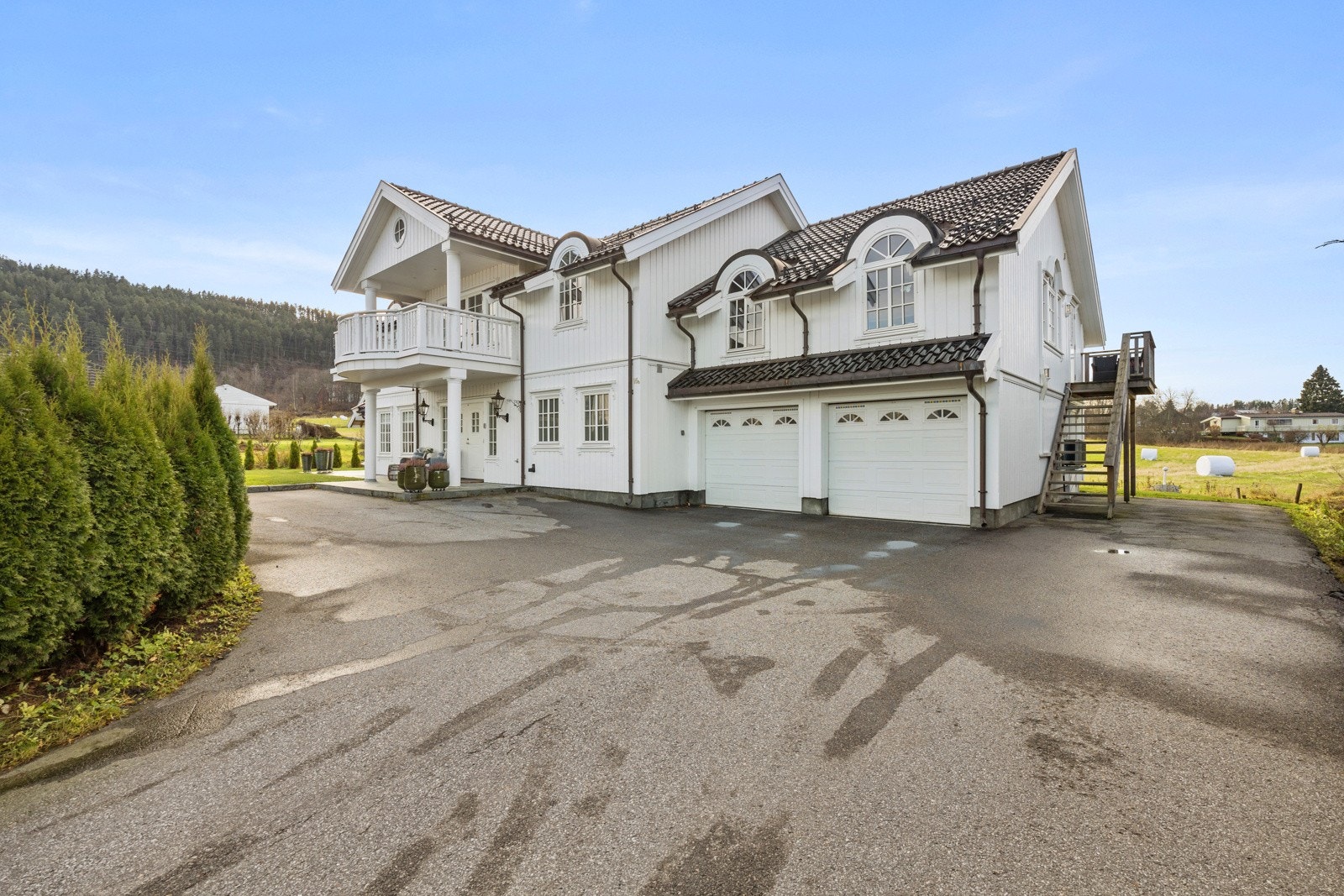 Asfaltert gårdsplass med god plass til kjøretøyene. Integrert dobbelgarasje med adkomst inn til huset. Galleribilde