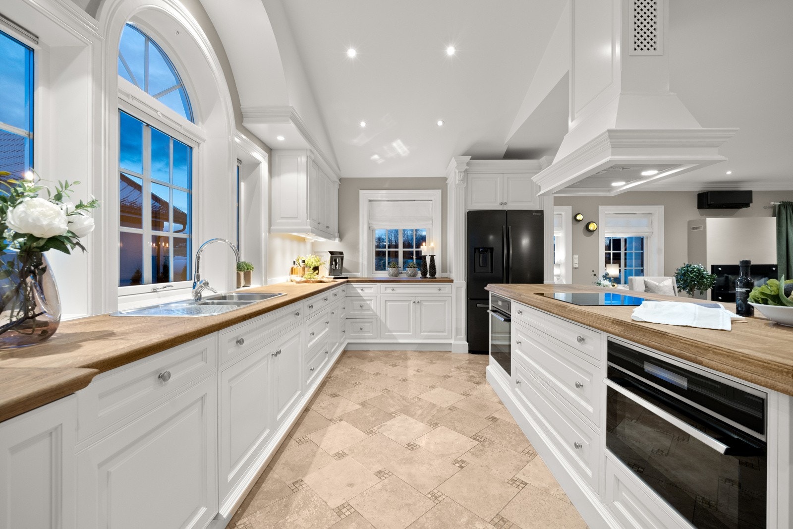 Romslig kjøkkenøy med takhengt ventilator over. Galleribilde