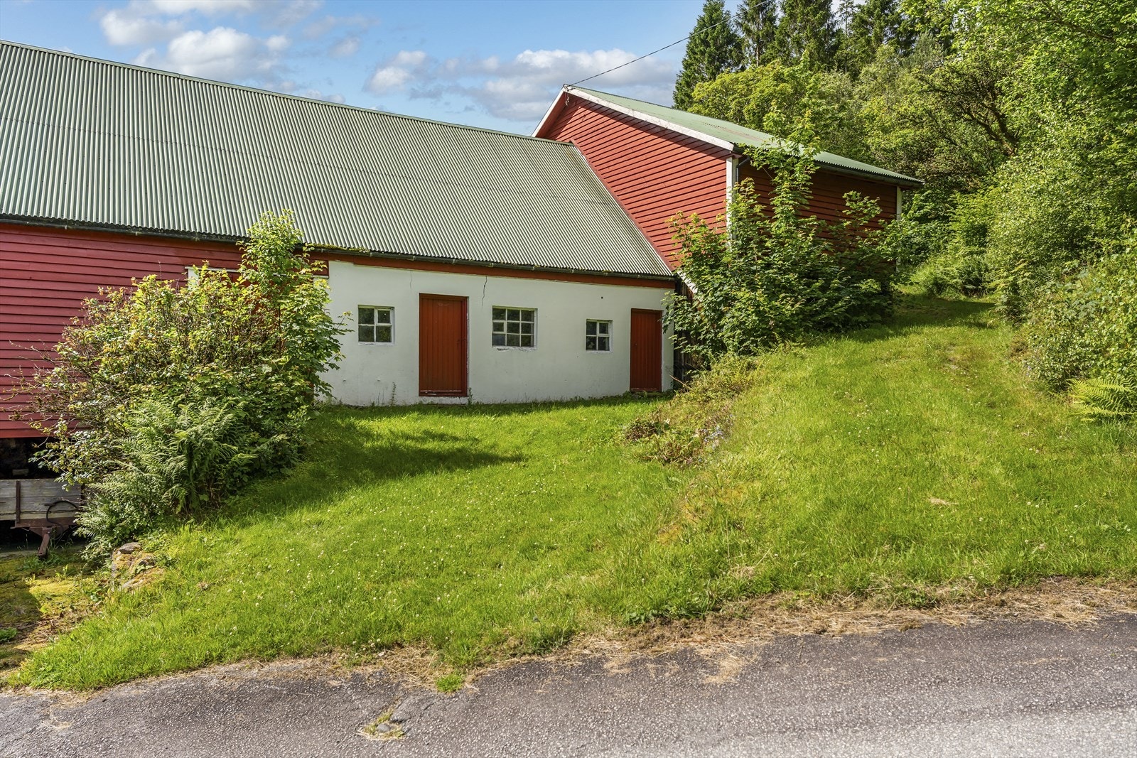 Gårdstun hvor løe, lagerbygg og garasjebygg ligger like nedenfor boligen Galleribilde