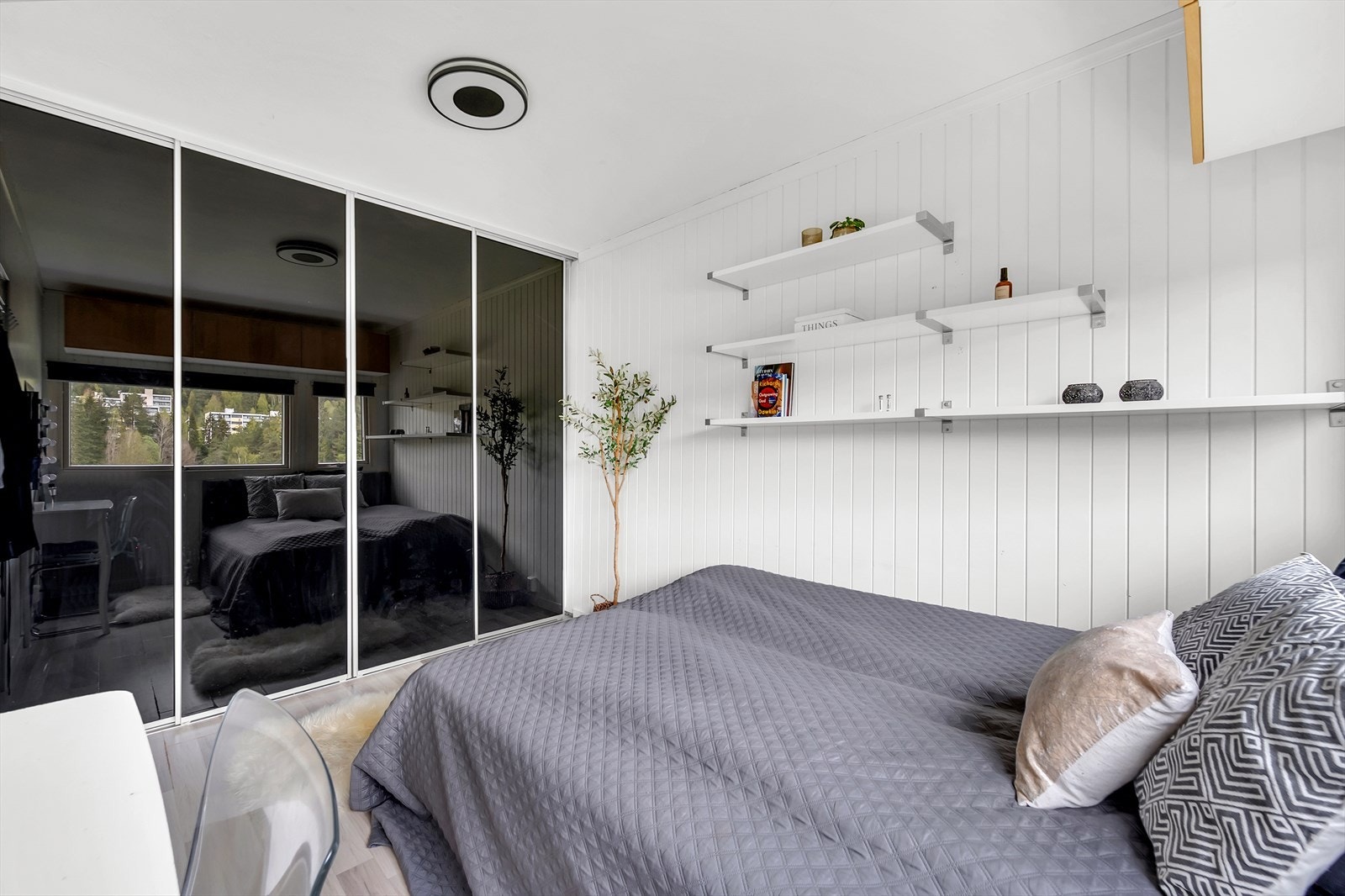 Soverommet har god plass til dobbeltseng, skrivebord og det medfølger skyvedørsgarderobe med mørke speilfronter. Galleribilde