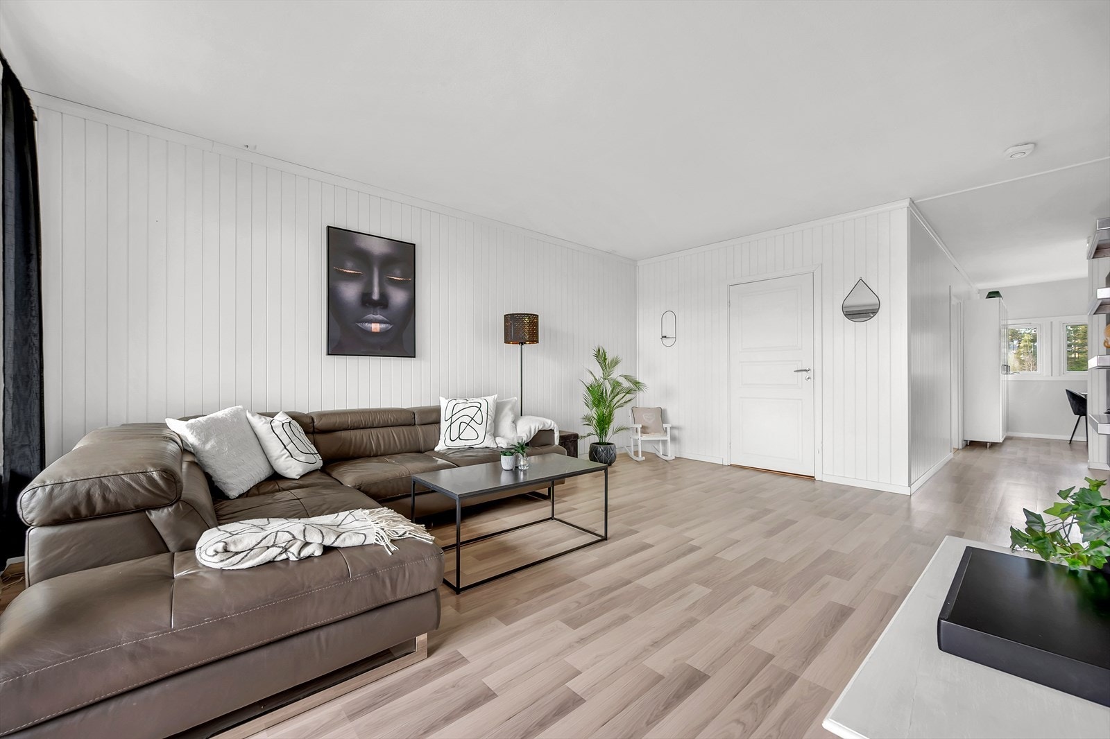 Takhøyden i stuen ble målt til 2,46m, det er laminat på gulv og vegger med malt betong, malte plater og panel. Galleribilde