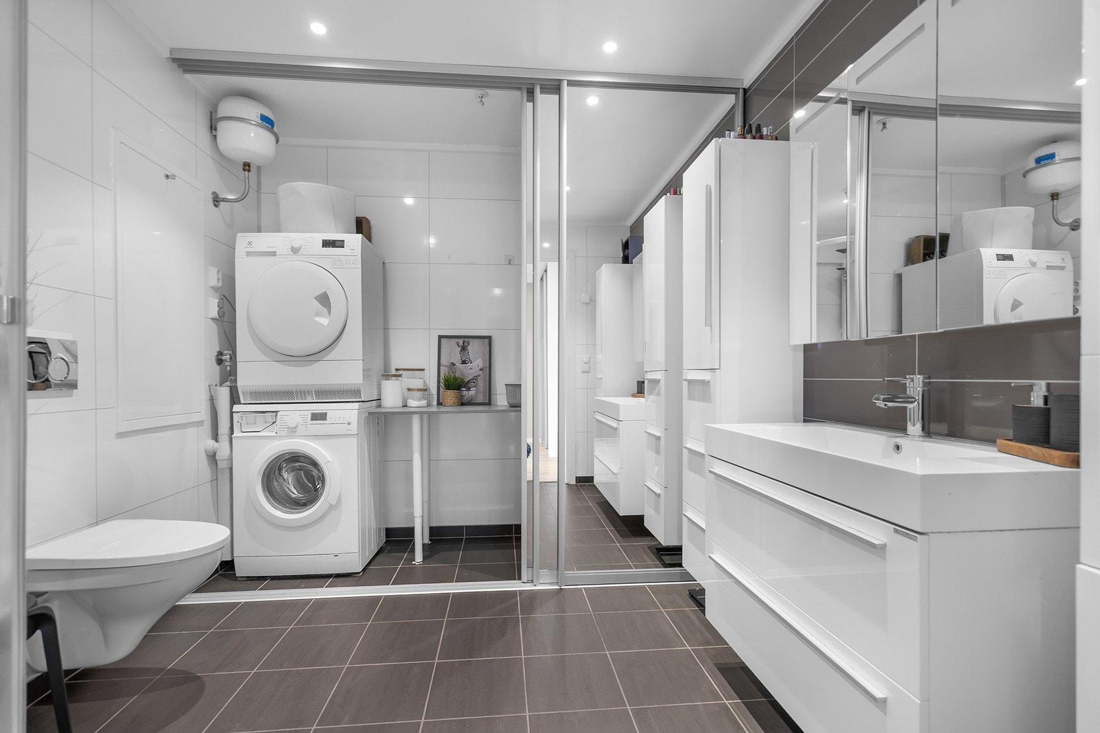 Bad med våtromsplater på vegger og flislagt gulv. Galleribilde