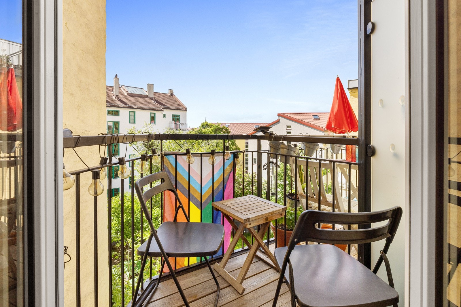 Balkongen har terrassebord på gulv og rekkverk av metall. Galleribilde