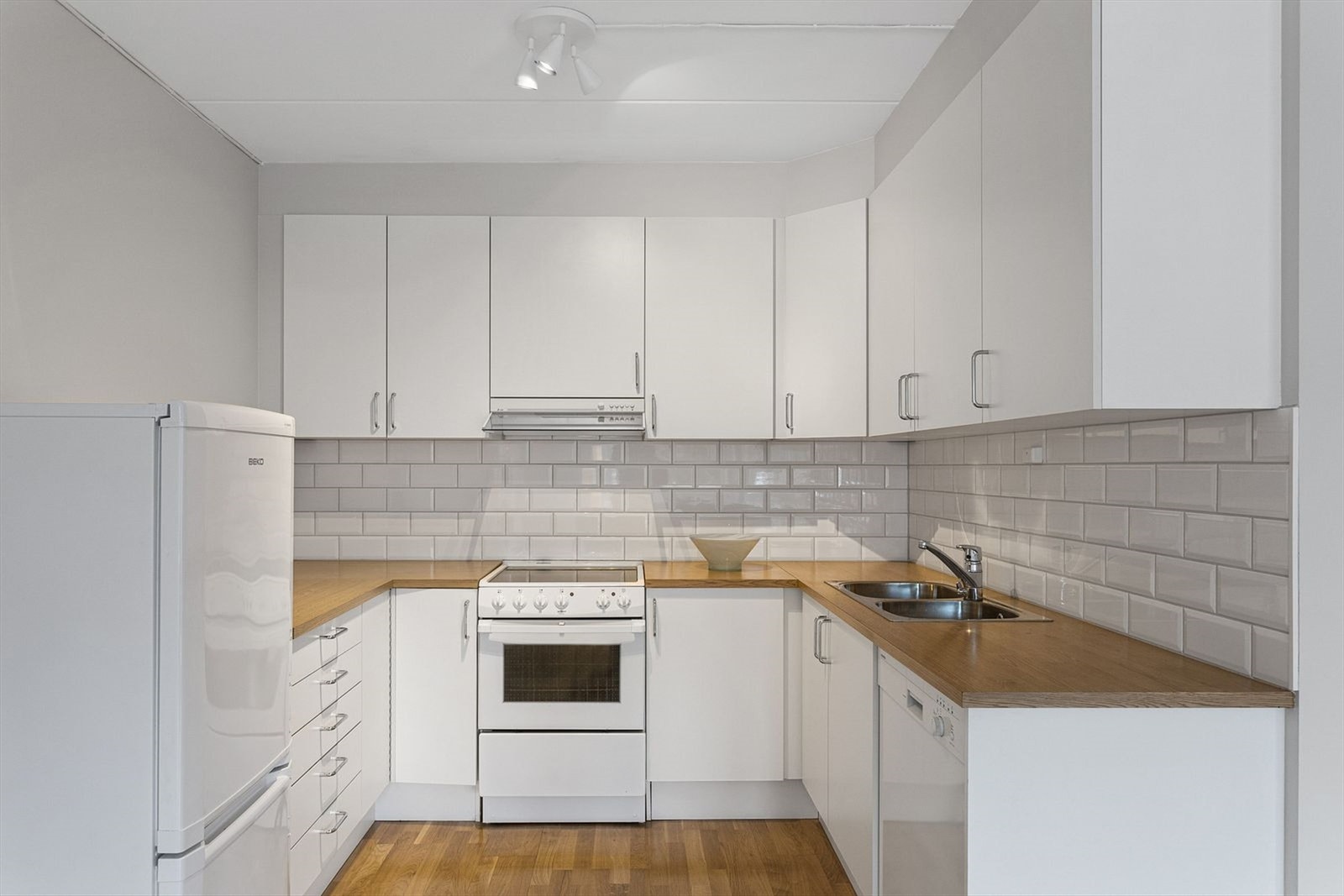 Åpen kjøkkenløsning med hvite fronter med god skap- og benkeplass. Hvitevarer på kjøkken medfølger. Galleribilde