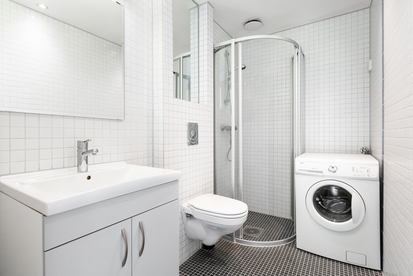 Flislagt baderom med varmekabler i gulv. Badet er innredet med dusjnisje med glassdør. Galleribilde