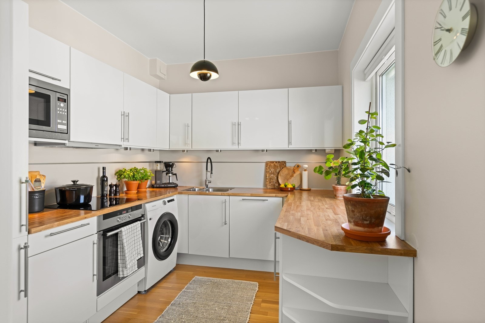 Kjøkkenet er innredet med moderne HTH-innredning i lyse toner og glatte fronter. Benkeplaten er i laminat og har nedfelt oppvaskkum med ettgreps blandebatteri (utskiftet i 2023). Galleribilde