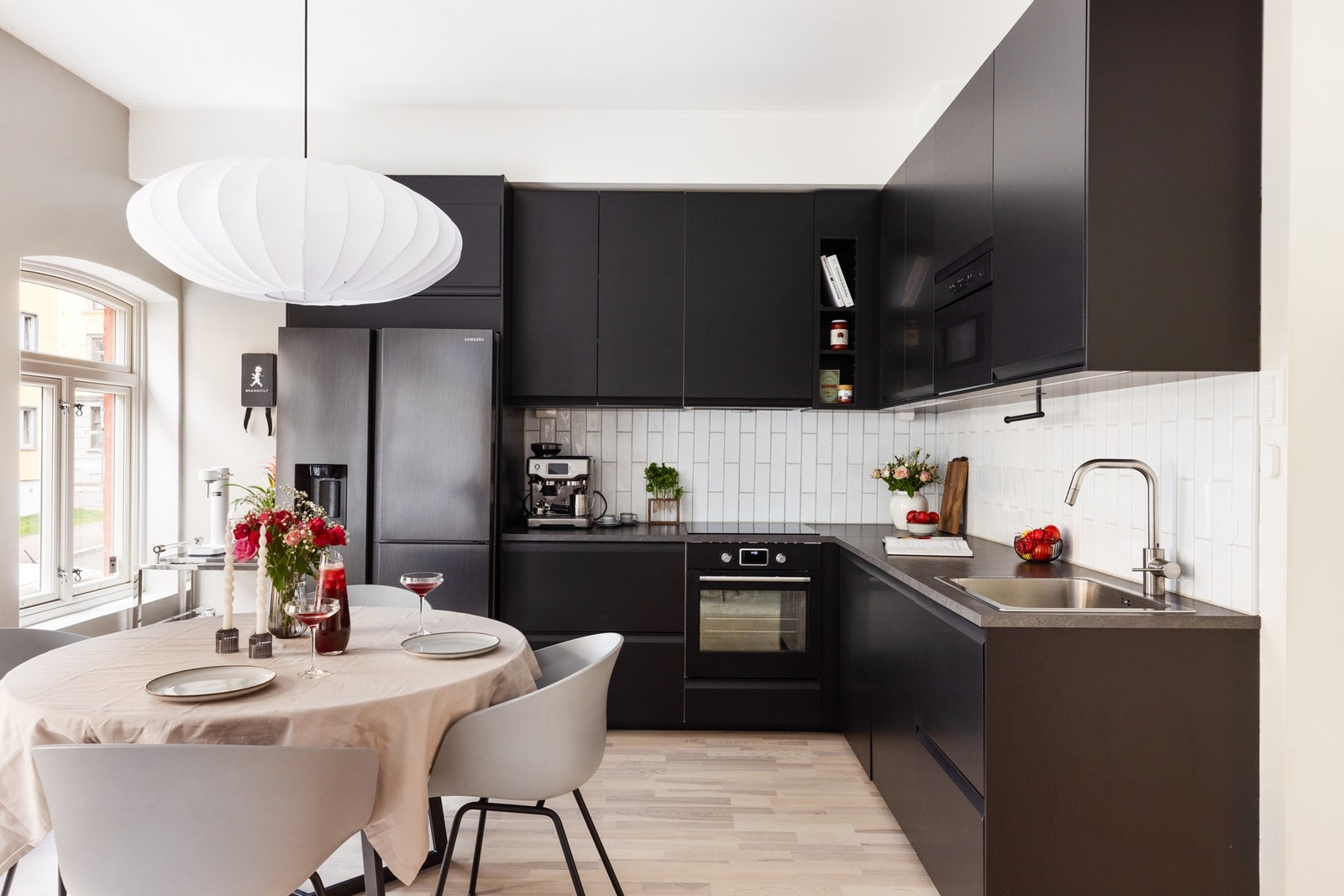 Innredningen har glatte fronter i elegant sort utførelse, kombinert med en benkeplate i laminat med nedfelt kum i rustfritt stål. Galleribilde