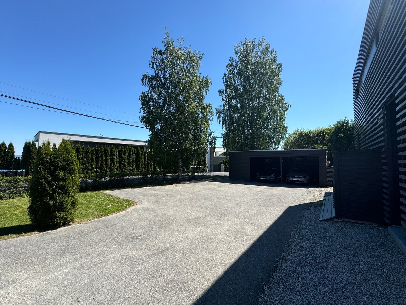 Gårdsplass med 2 biloppstillinger og carport Galleribilde