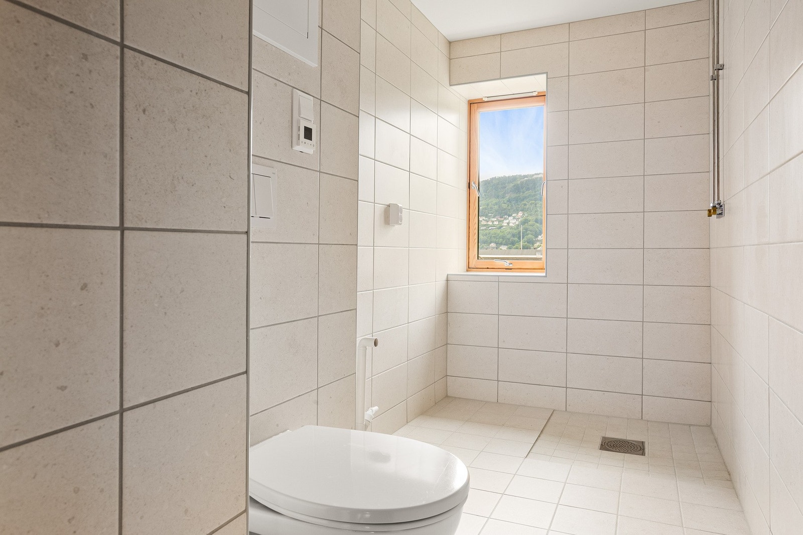 Badet er helfliset med malte slette flater i taket og varmekabler i gulv. Galleribilde