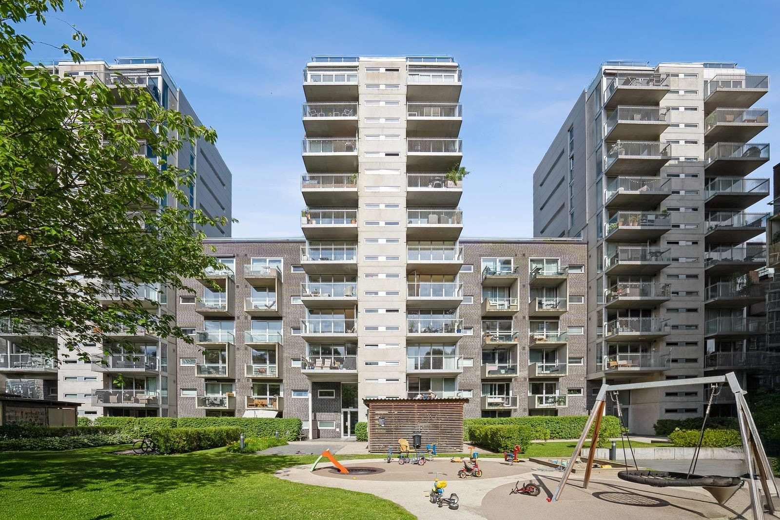 Åpent gårdsrom med lekeplass som skaper et varnevennlig og innbydende miljø. Galleribilde